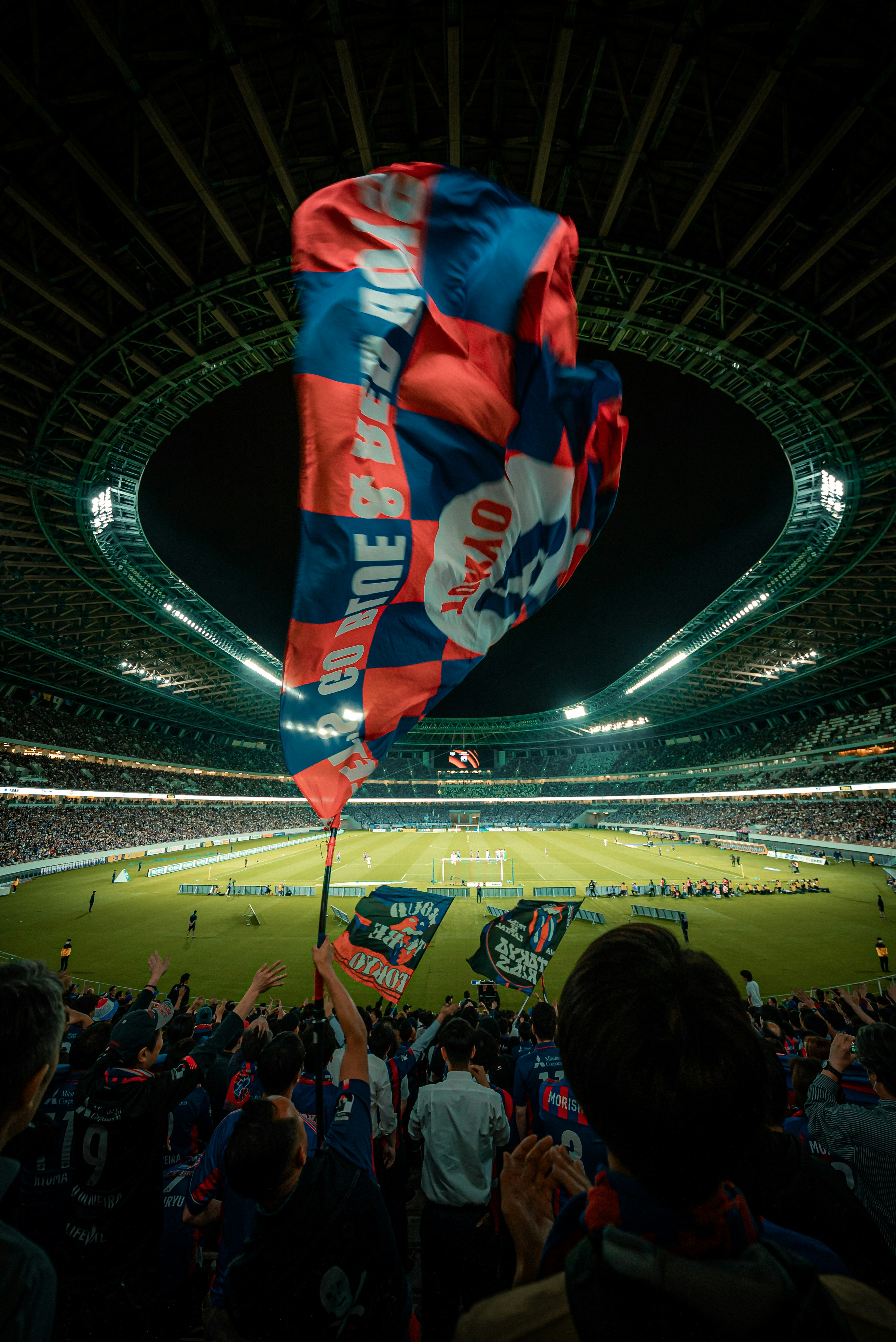 Menschenmenge, die Fahnen in einem Fußballstadion schwenkt