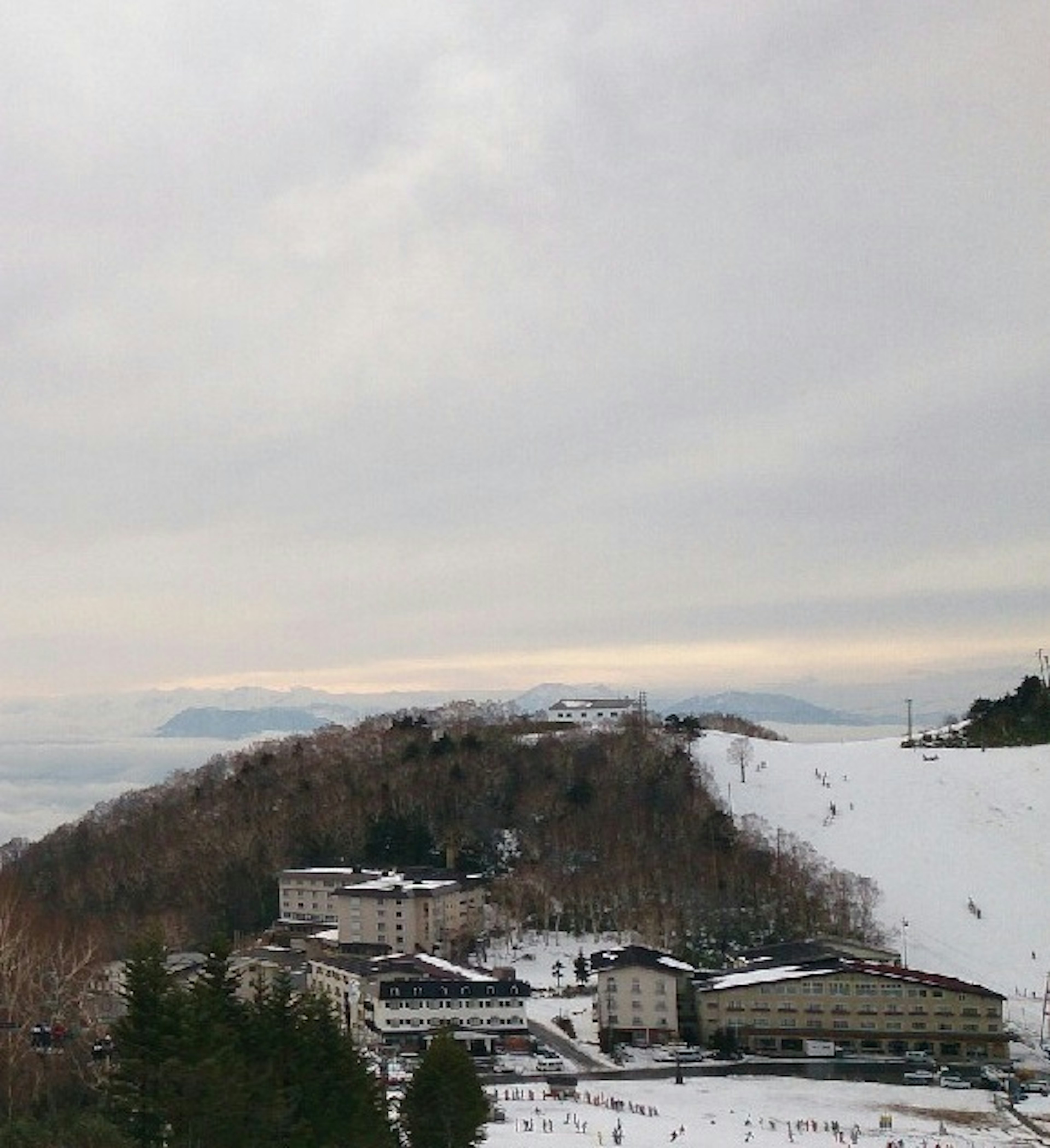 Lodging facility on a snowy mountain slope with distant mountains