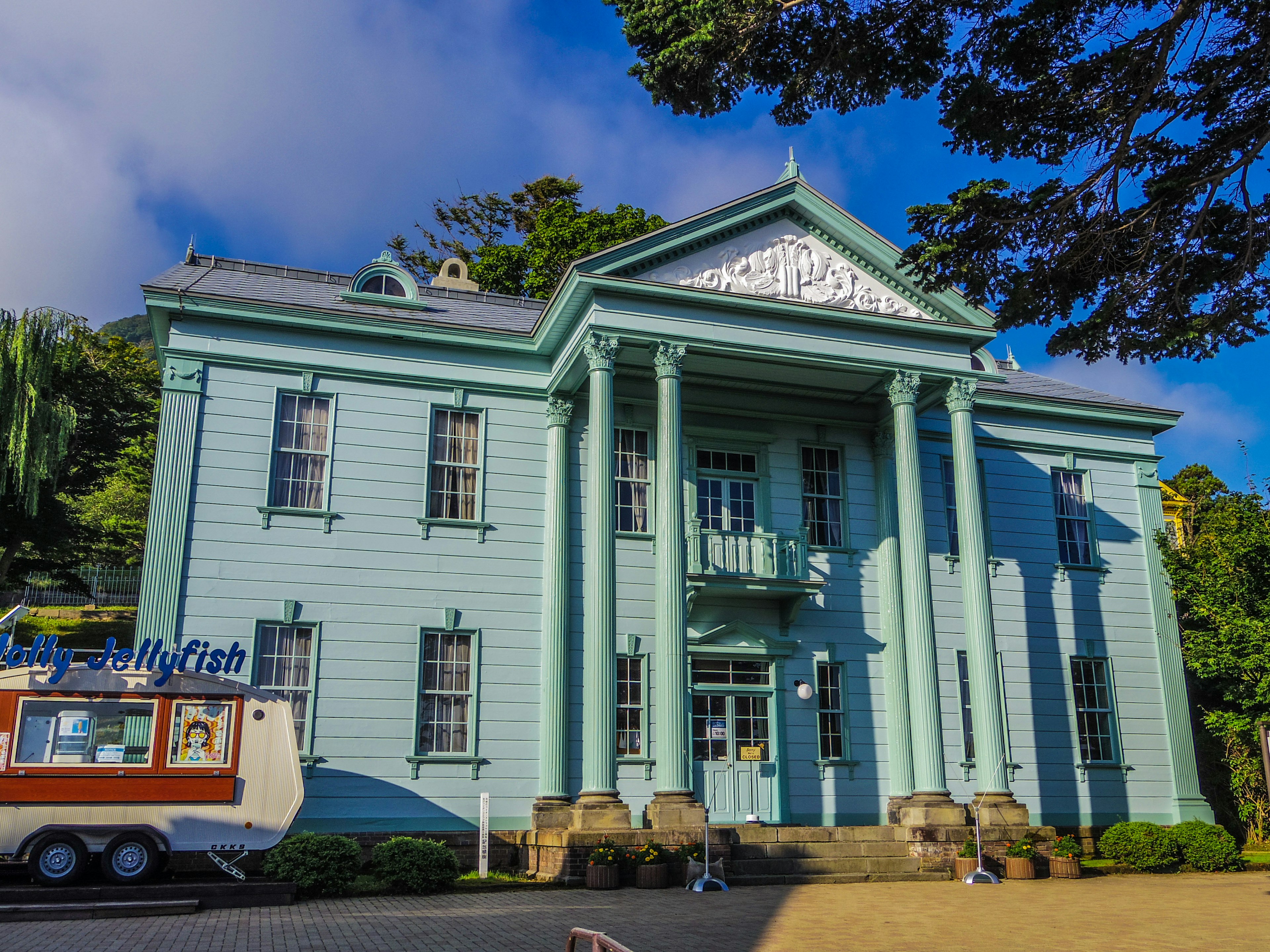 Historic building with blue exterior and food truck