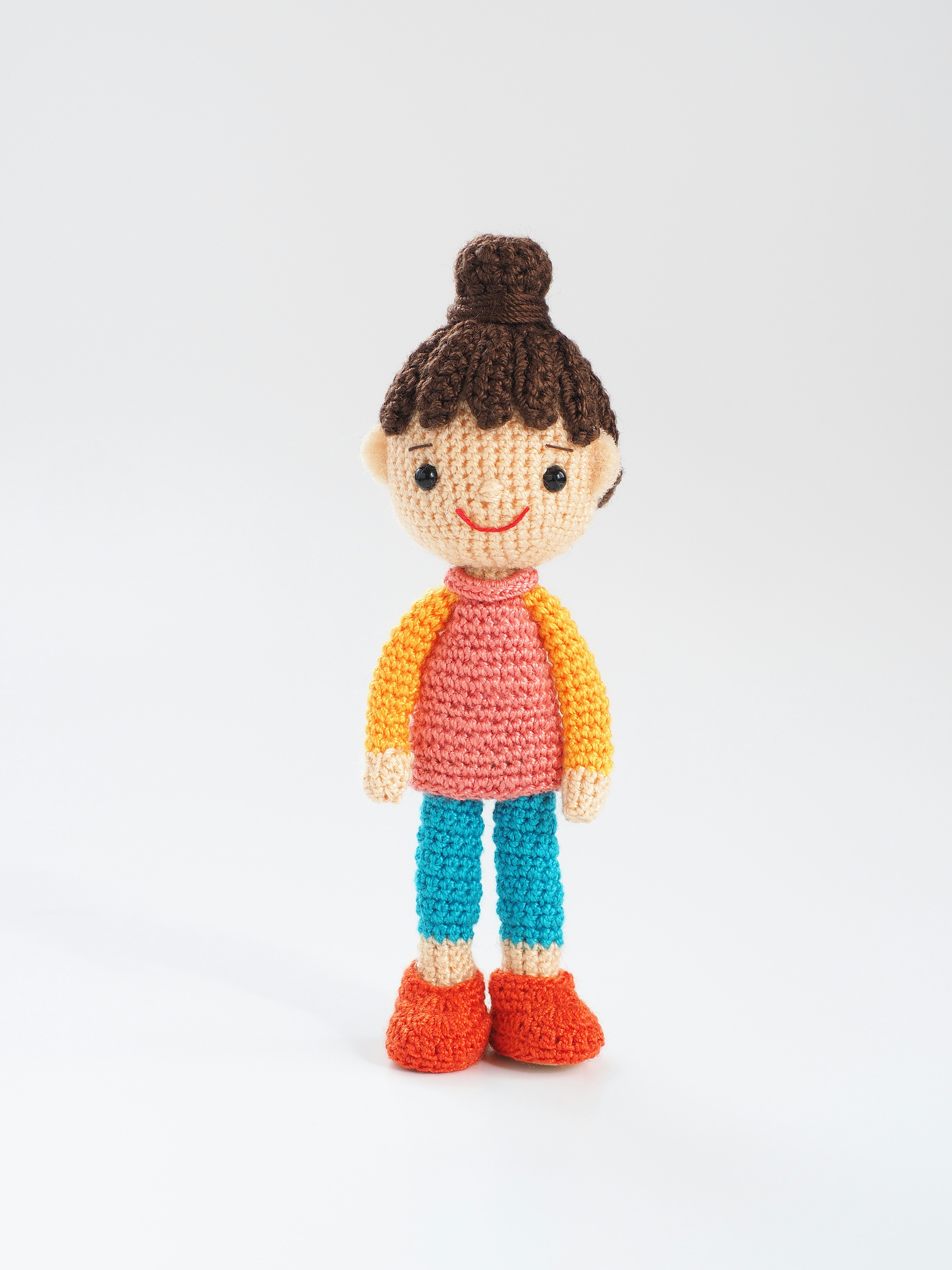 A colorful crocheted girl doll standing upright