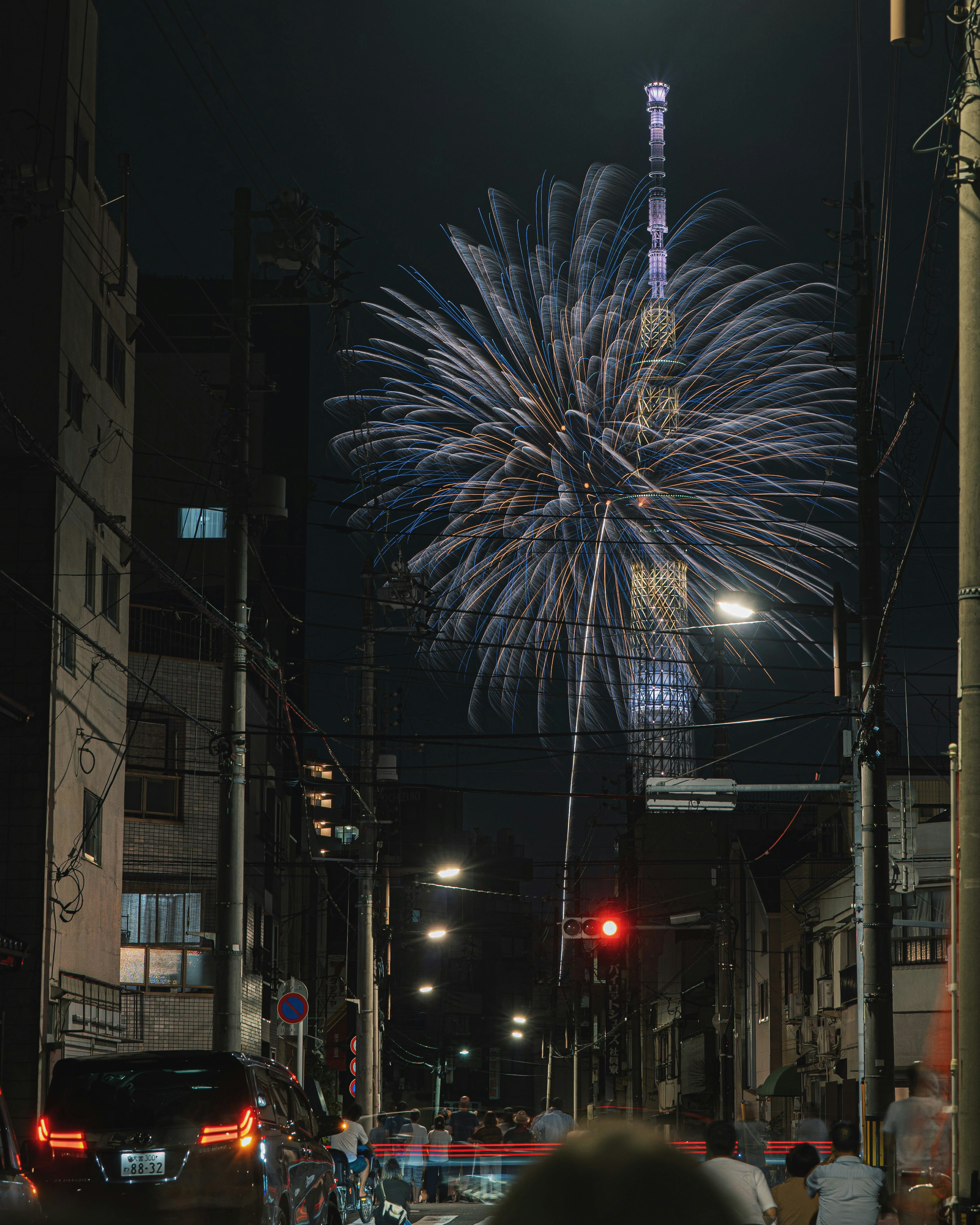 Kembang api meledak di langit malam dengan Tokyo Skytree terlihat di latar belakang