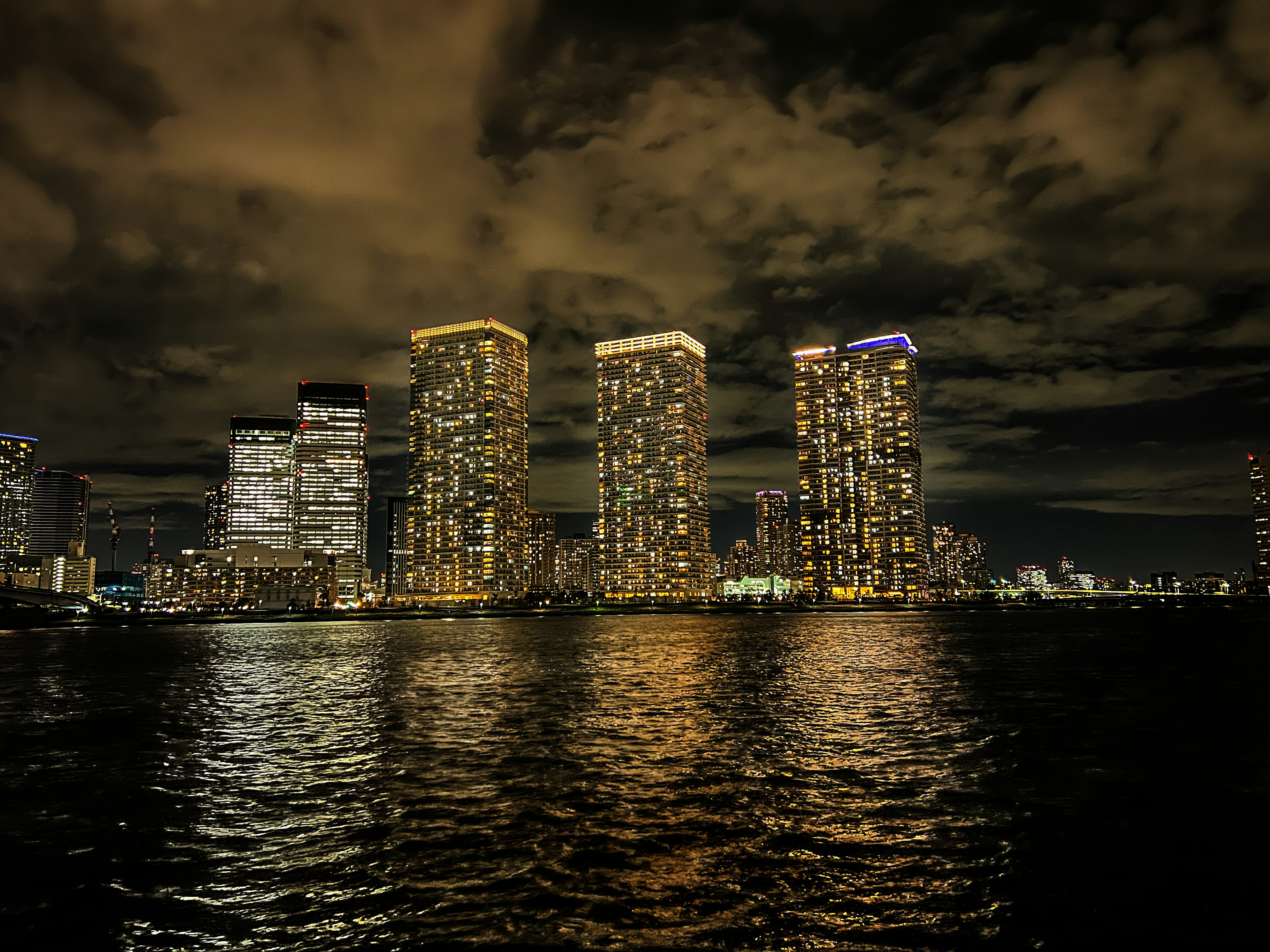 Vue nocturne de gratte-ciels se reflétant sur l'eau