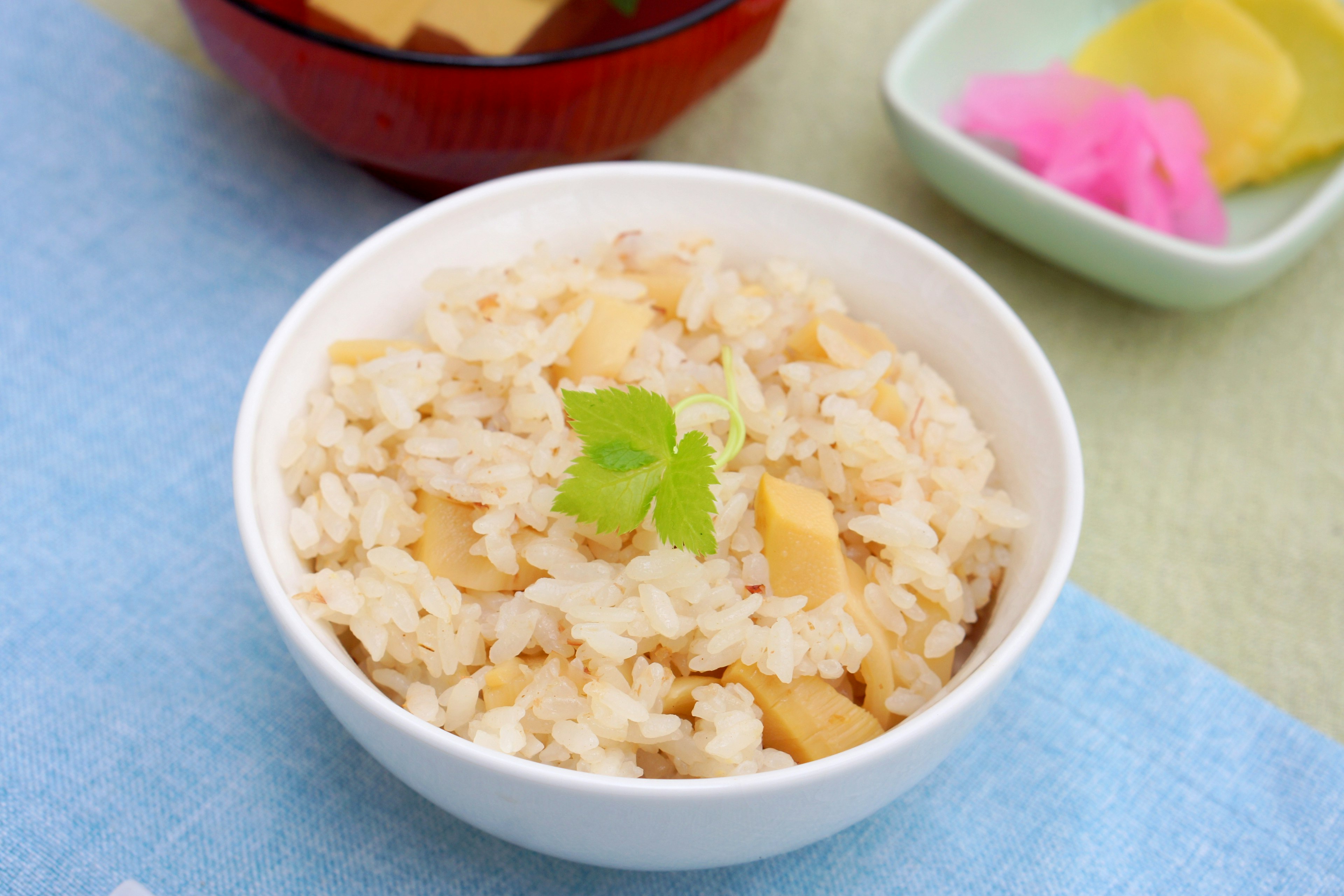 Bowl of bamboo shoot rice garnished with green leaf