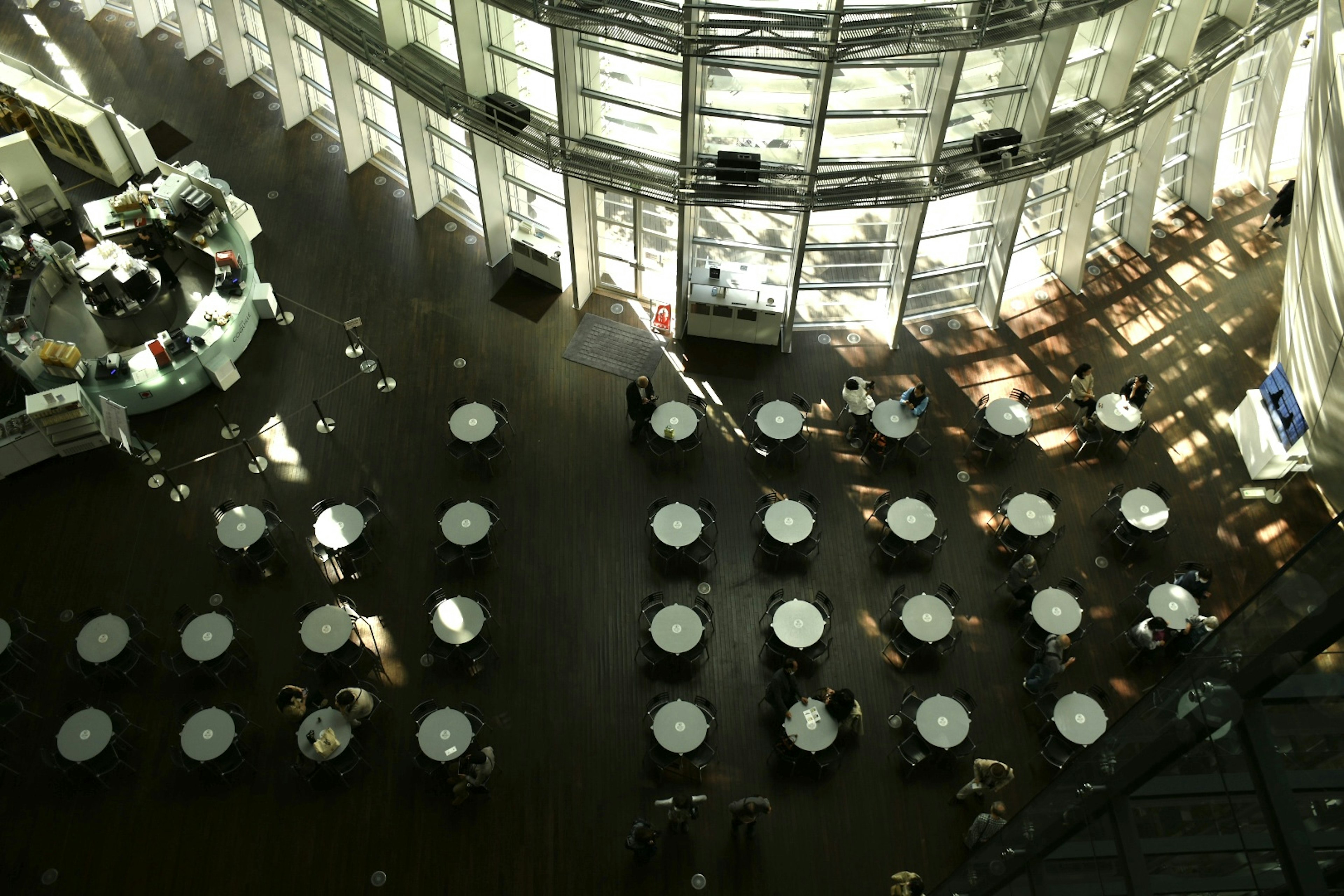 A spacious dining area with white tables and chairs arranged