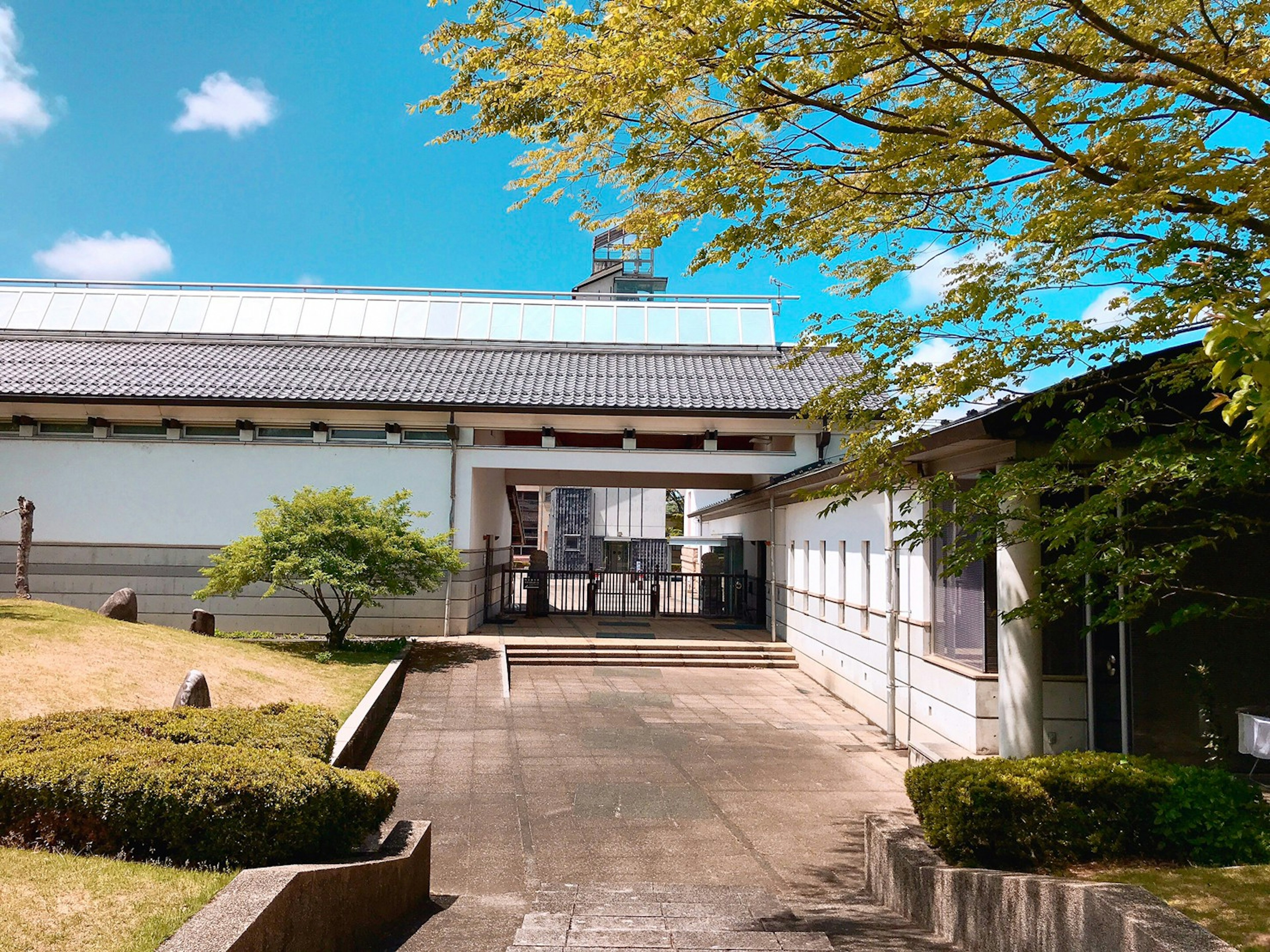 Exterior view of a traditional building surrounded by greenery and blue sky