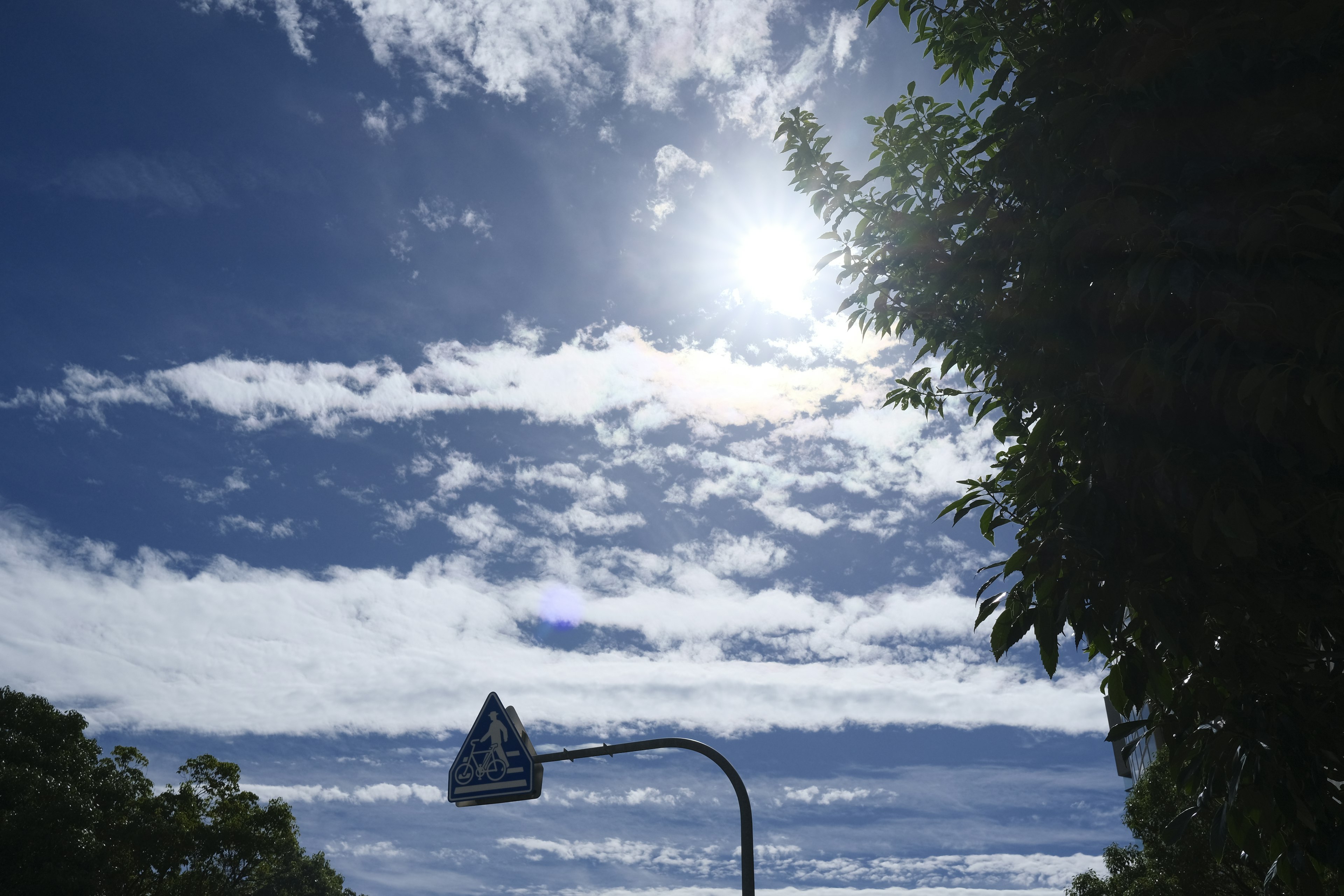 A streetlight under a blue sky with scattered clouds