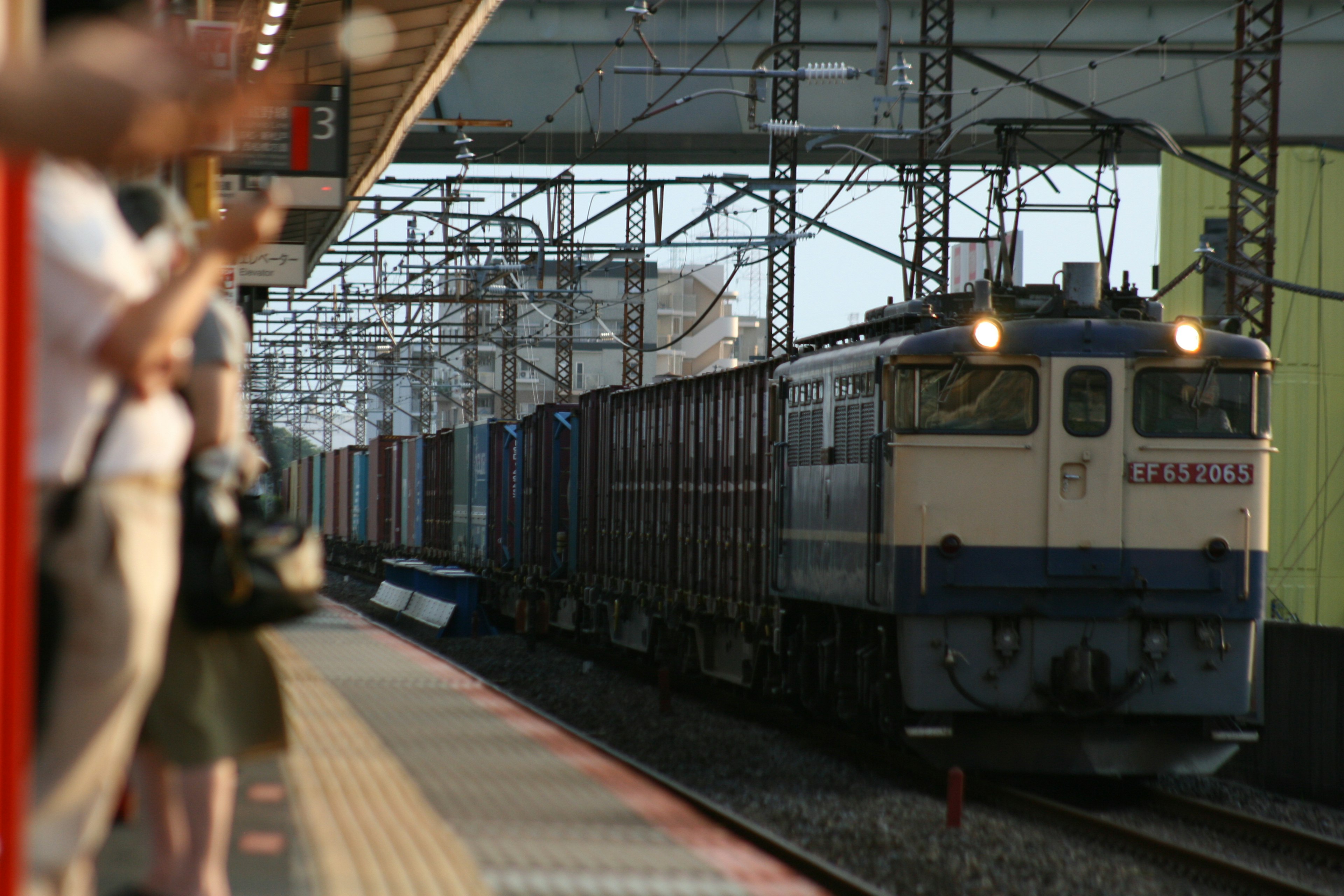 駅のプラットフォームで貨物列車が通過するシーン