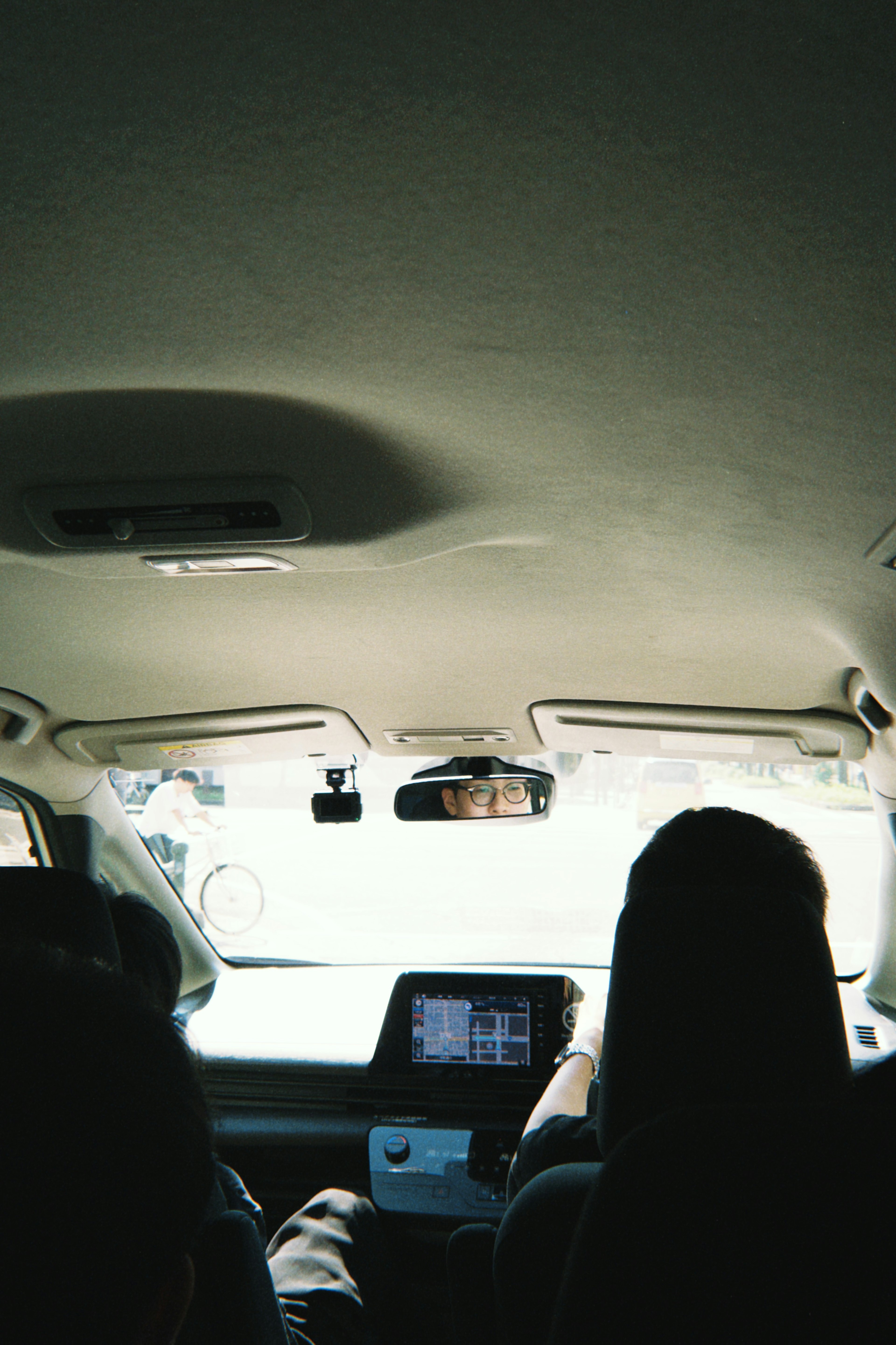 Vista desde el asiento trasero de un coche mostrando a una persona conduciendo