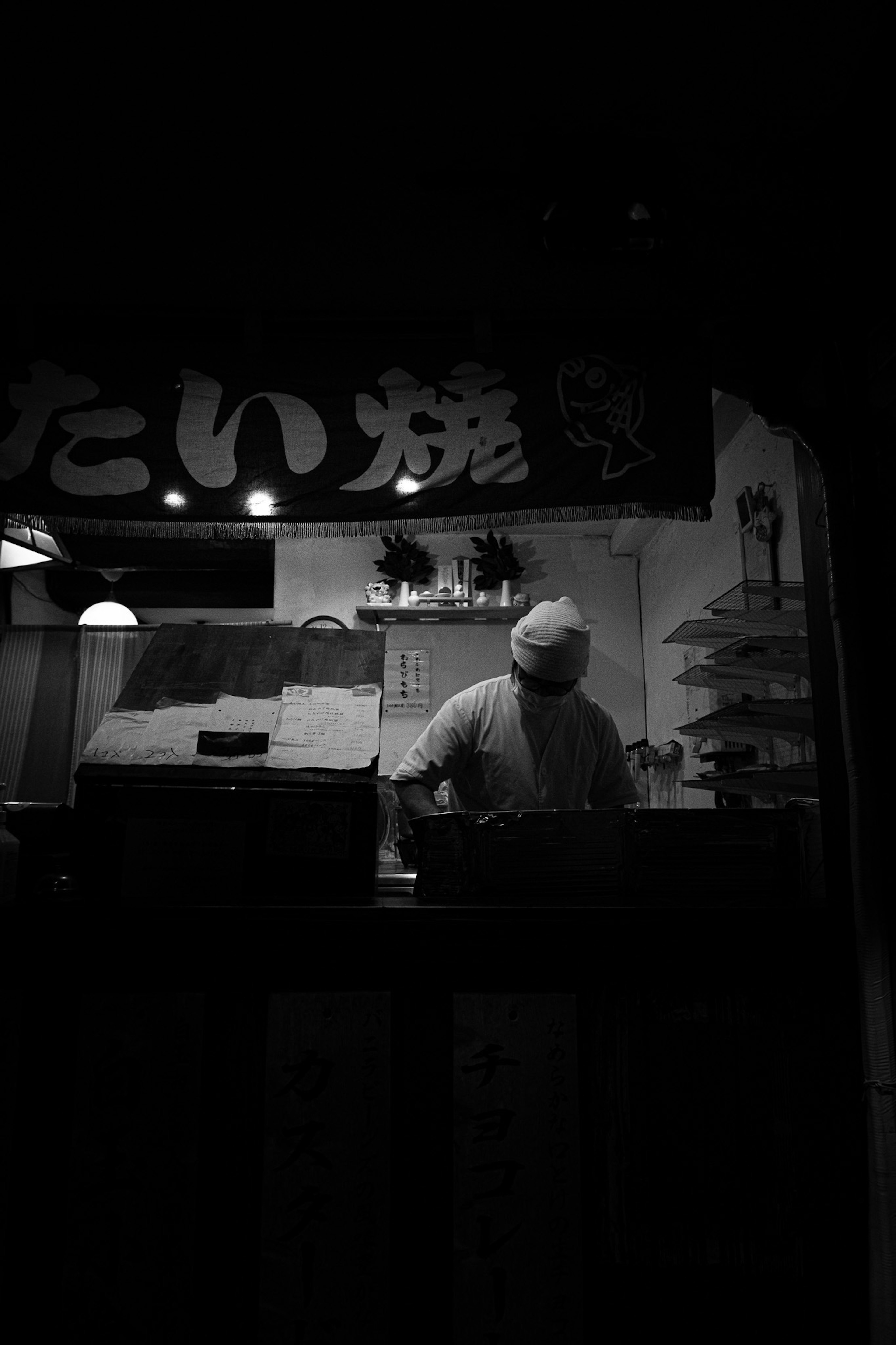 Chef preparando comida en un puesto débilmente iluminado