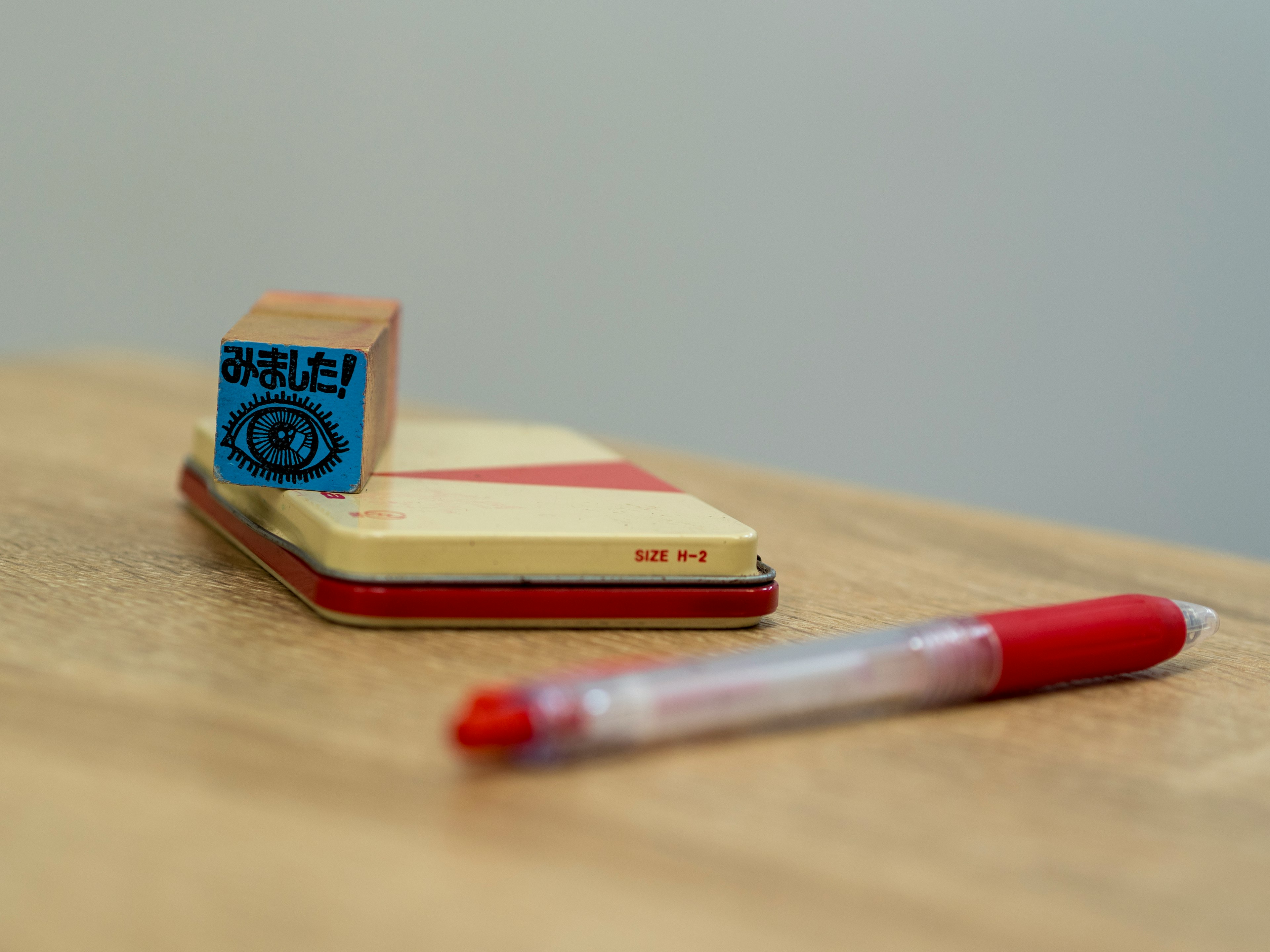 Red pen and stamp on a notebook placed on a wooden table