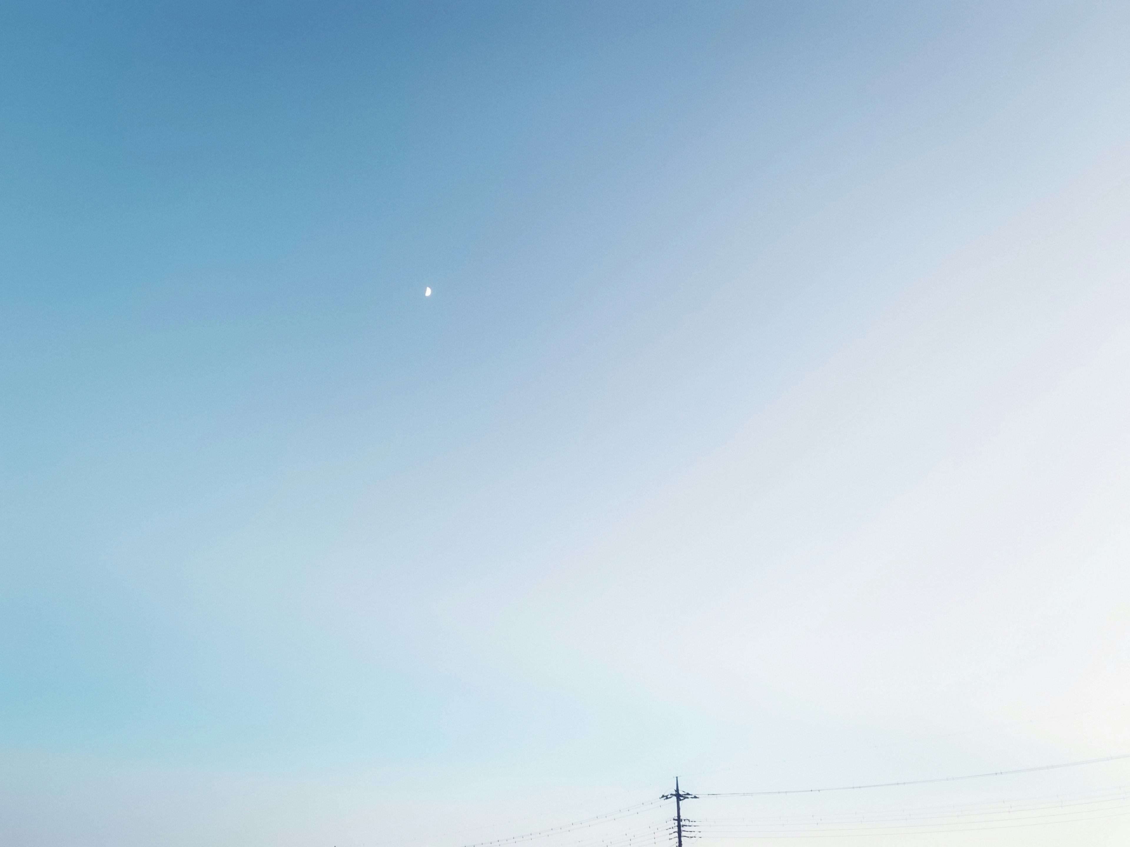 Cielo azul claro con una pequeña luna blanca