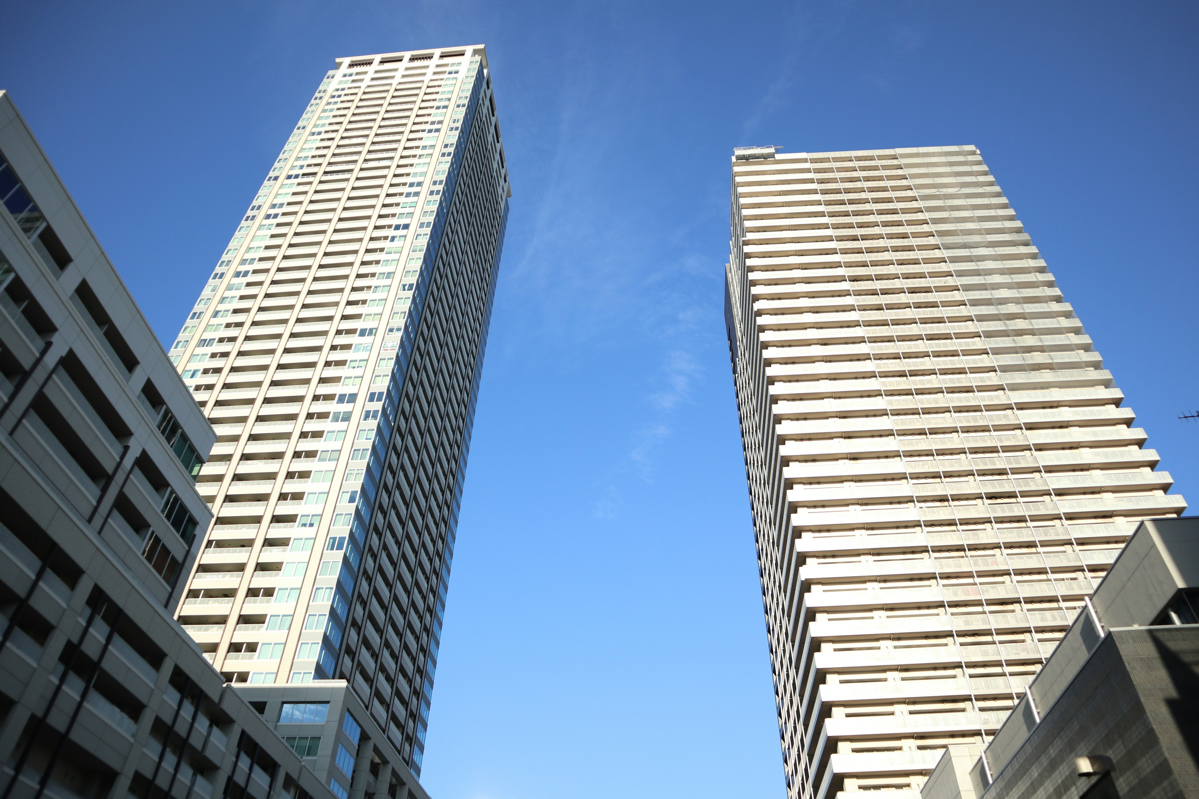 Gedung pencakar langit modern menjulang di bawah langit biru yang cerah