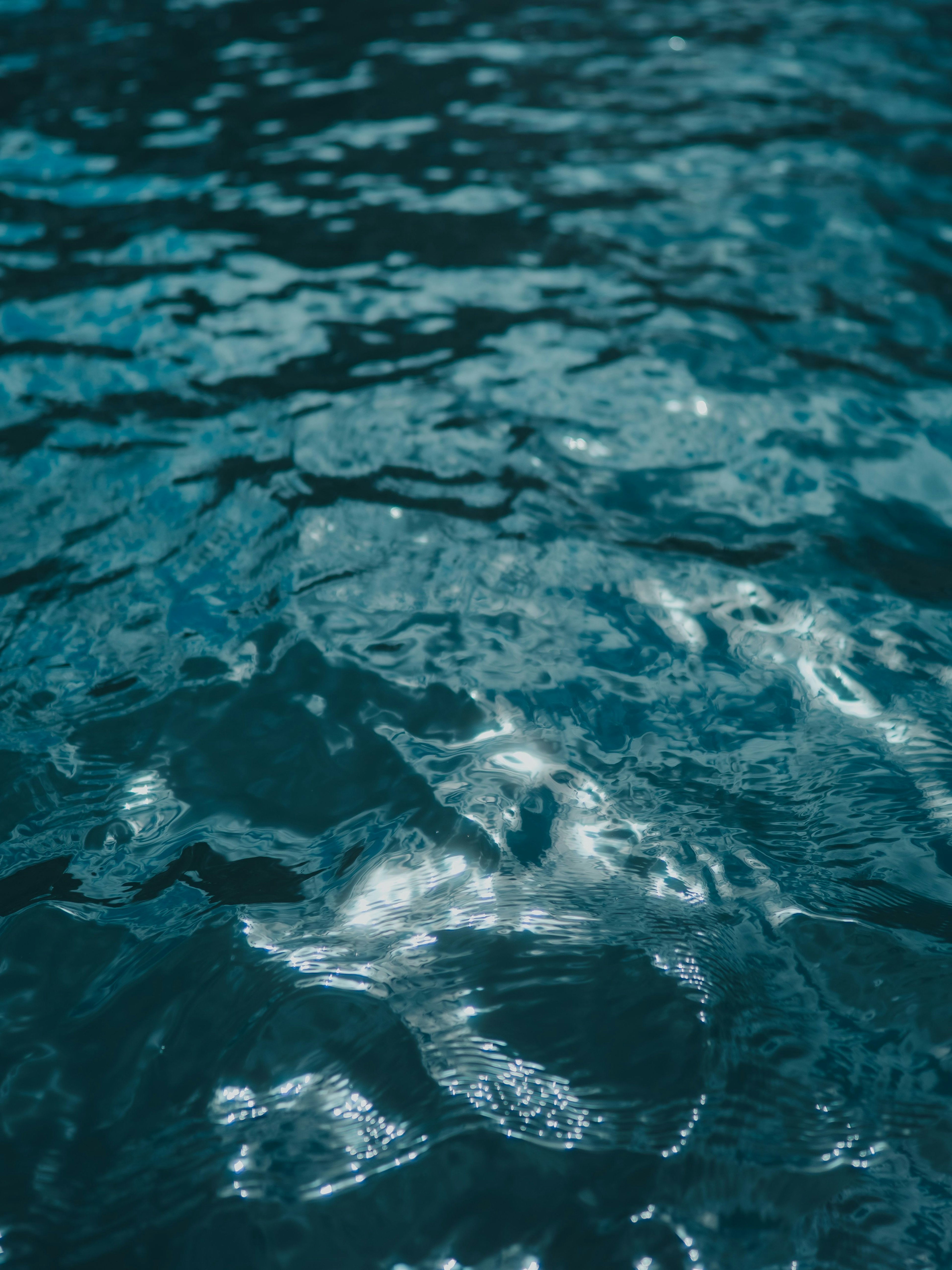 水面の波紋と光の反射が美しい青い水