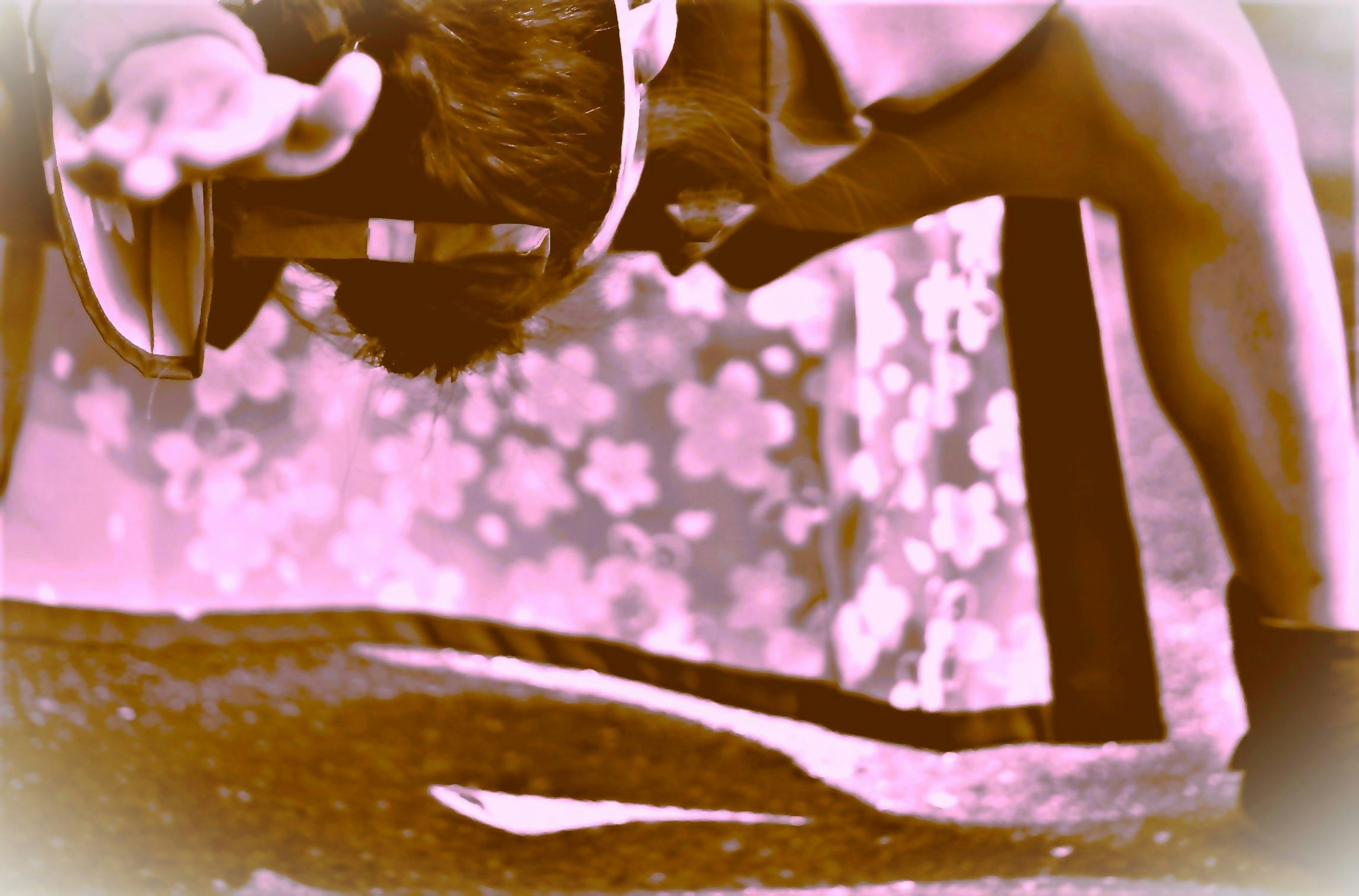 Person exercising in an inverted position with a floral patterned background in pink tones