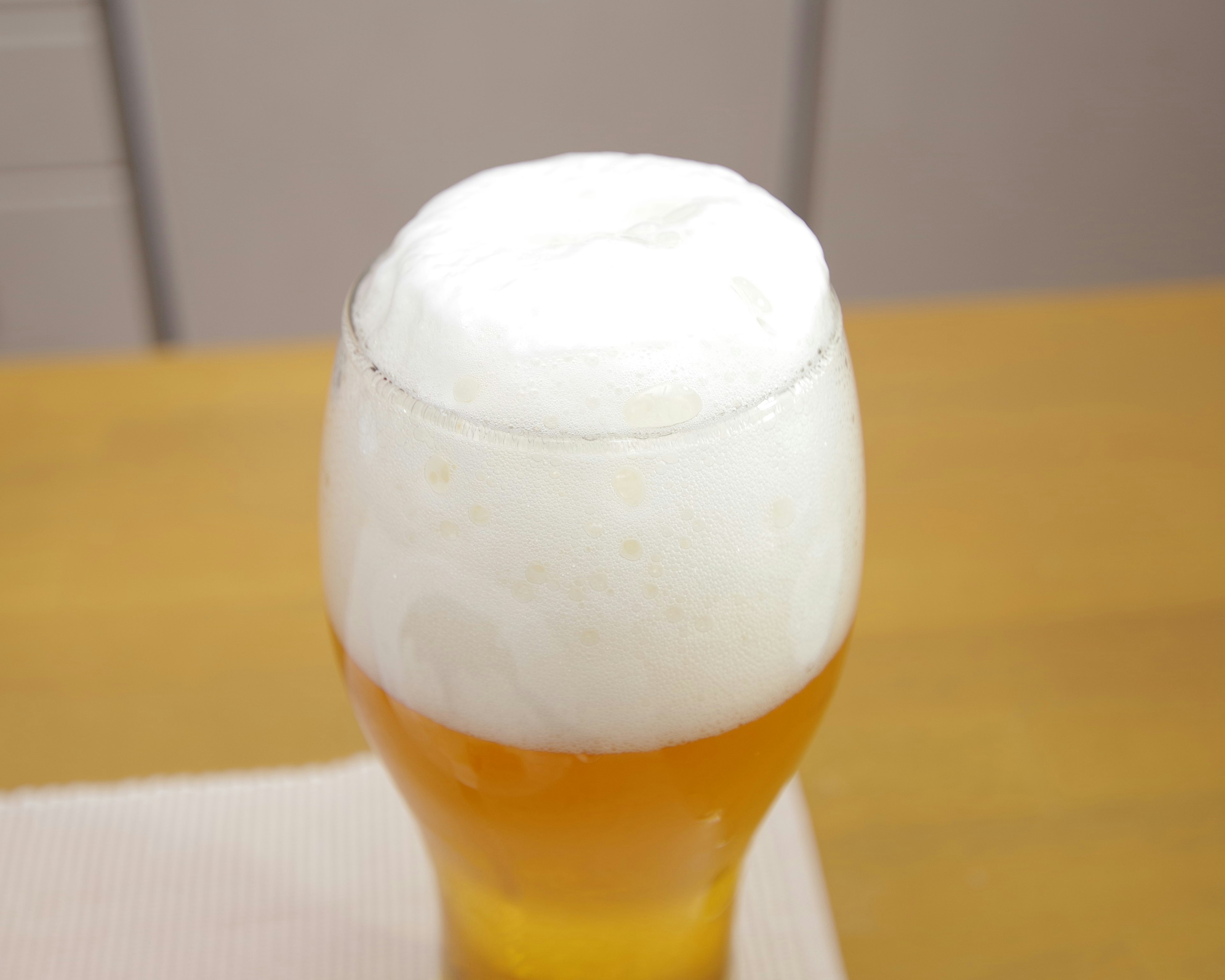 Photo of a glass of beer with a frothy head