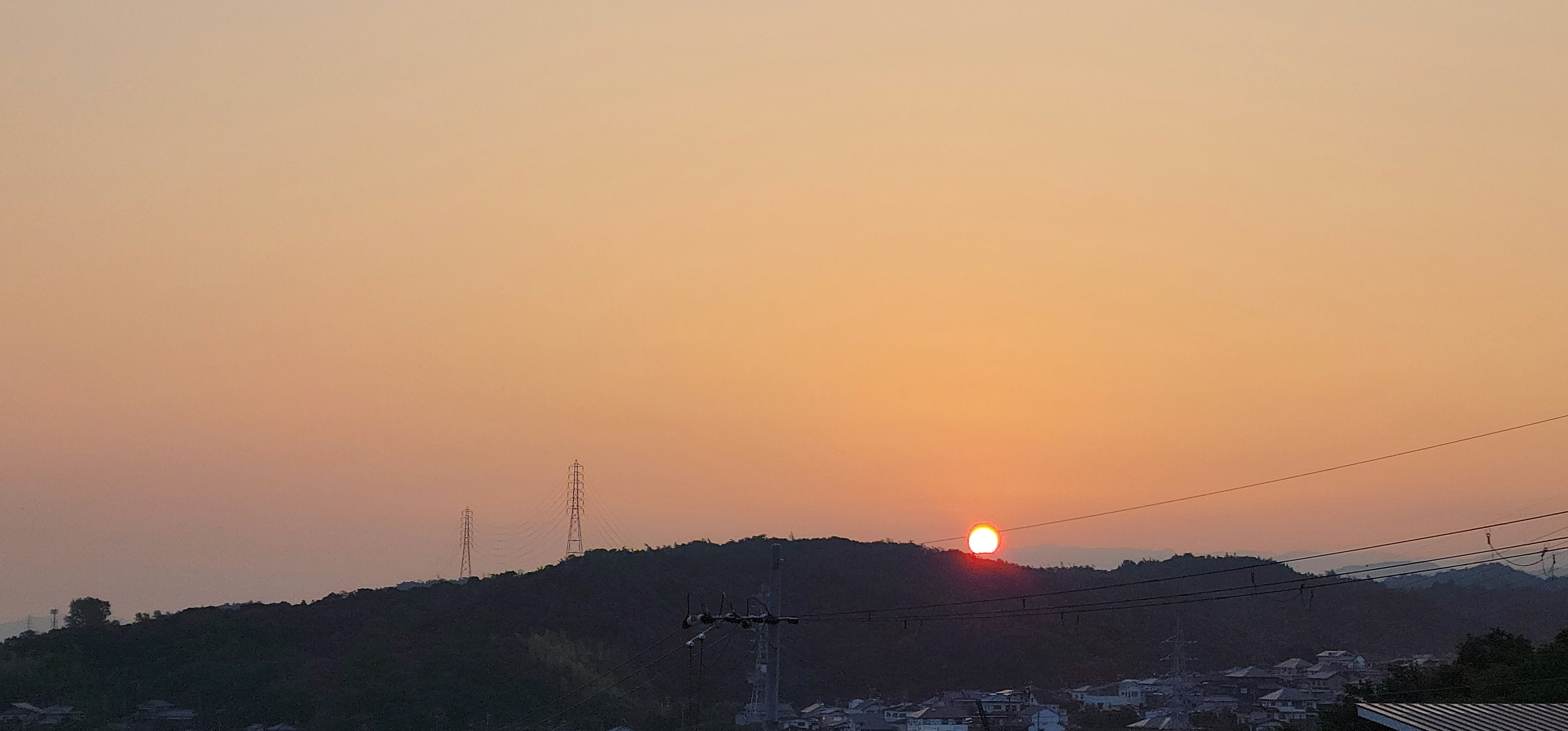 夕日が沈む丘の風景を捉えた画像