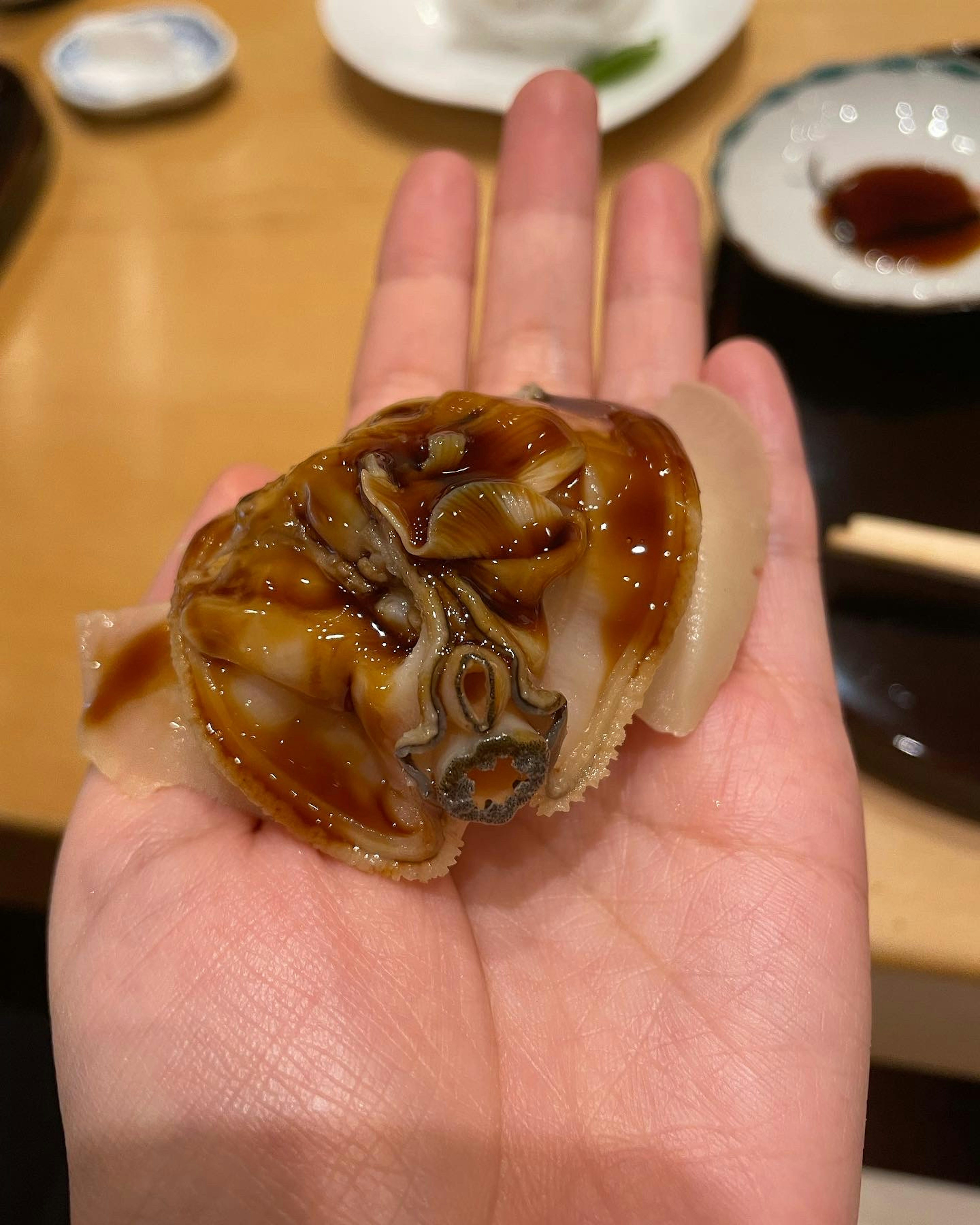 手のひらに乗せられた新鮮な海鮮料理の皿