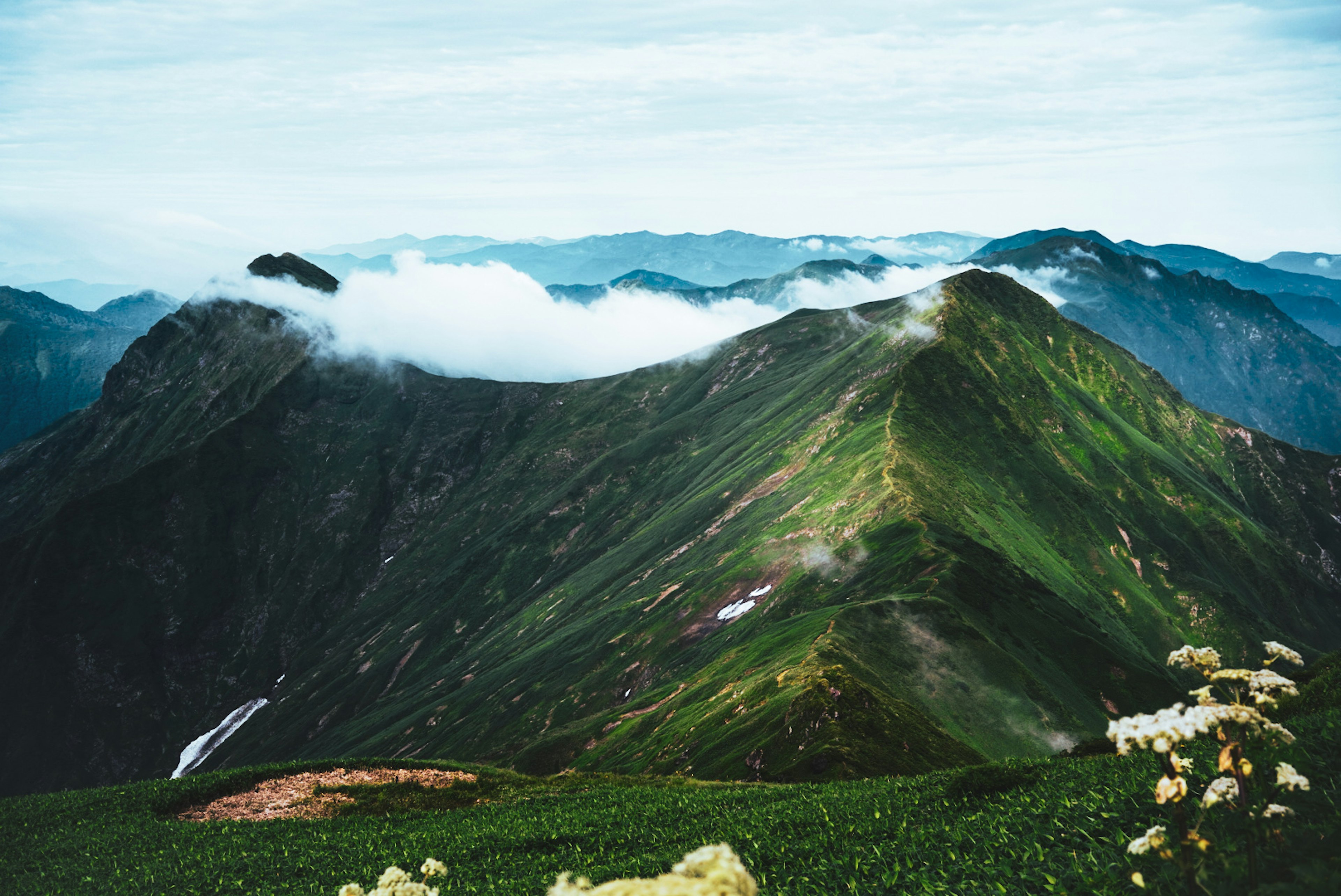 緑豊かな山脈と雲がかかった風景