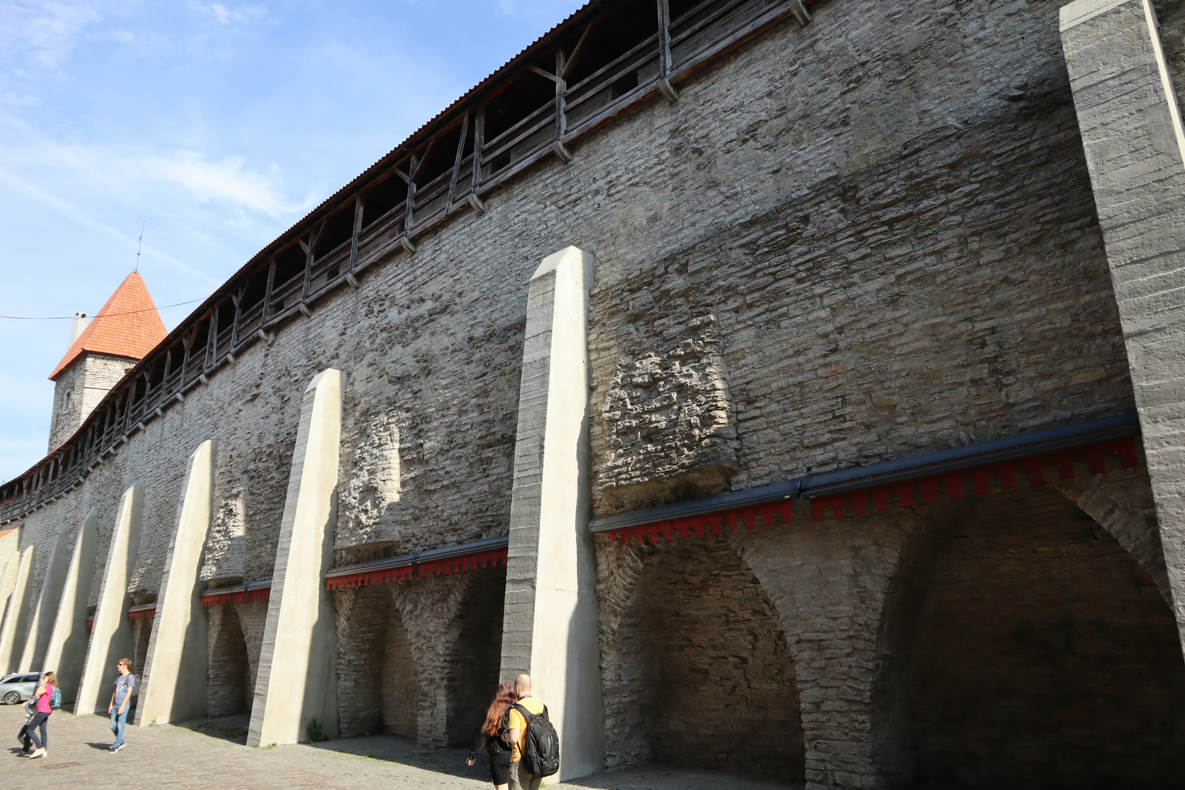 Historische Steinmauer mit darunter liegenden Bogenstrukturen, die mittelalterliche Architektur zeigen