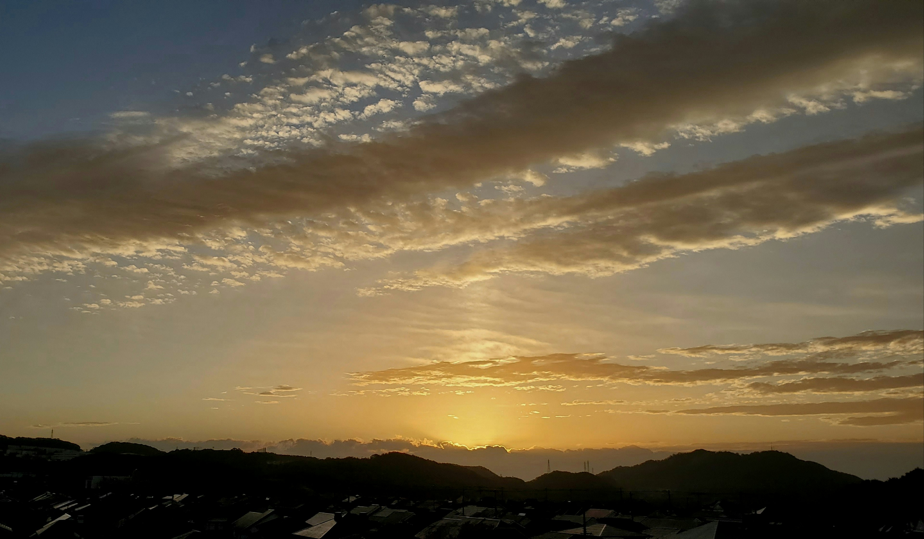 Hermoso paisaje de atardecer con capas de nubes y siluetas de montañas