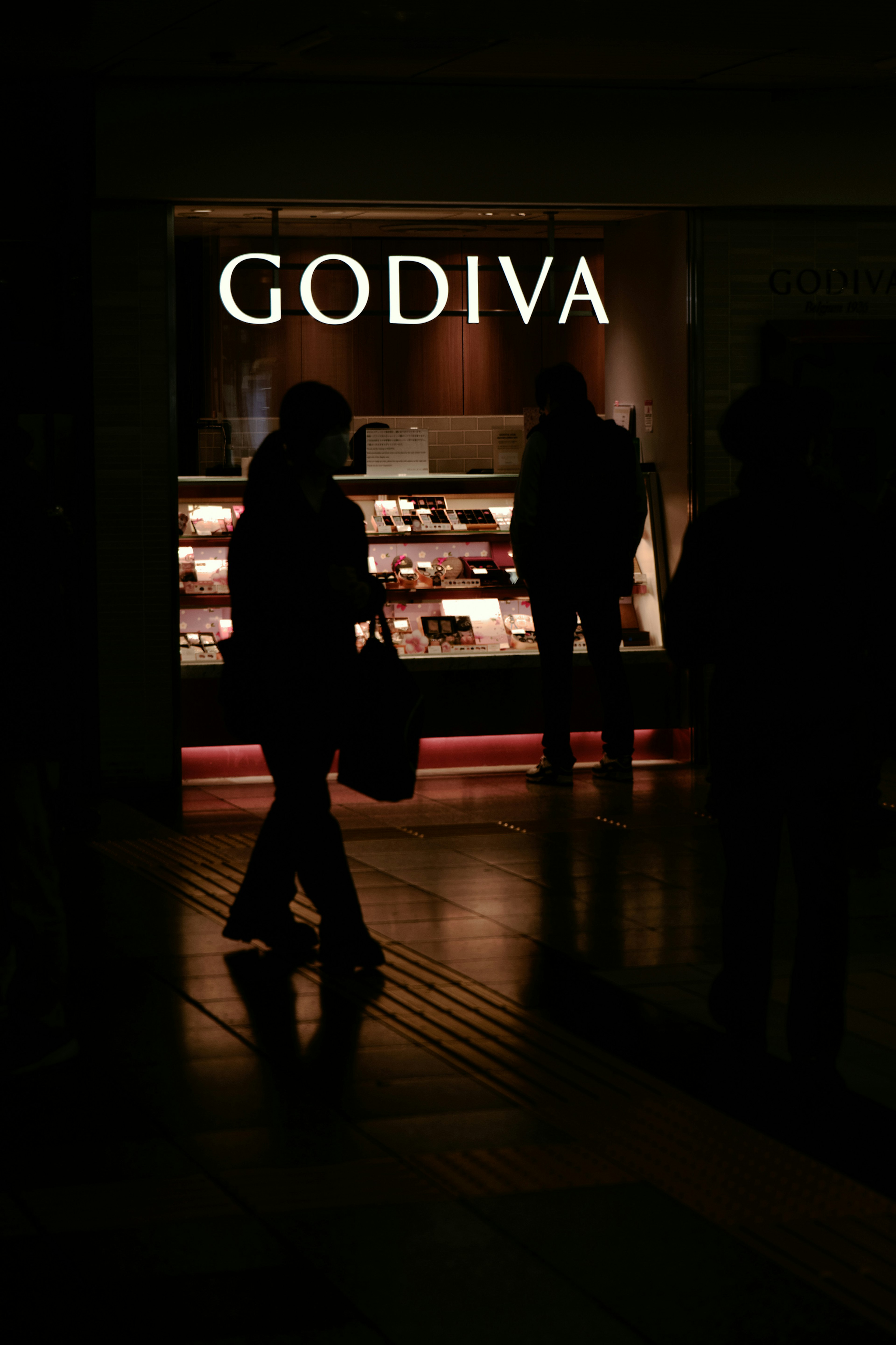 Vitrina de la tienda Godiva iluminada en un entorno oscuro