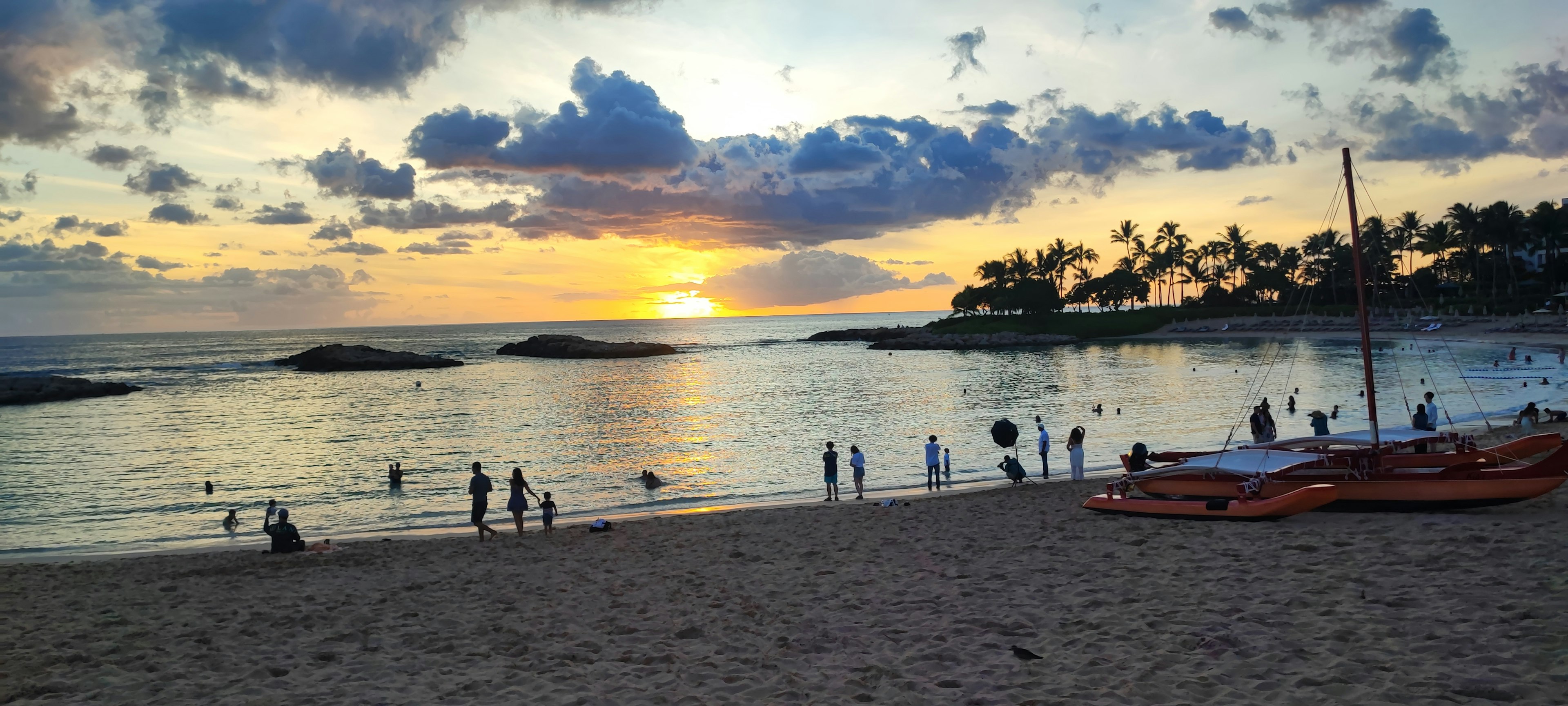 Scena di spiaggia con tramonto persone che si divertono in acqua