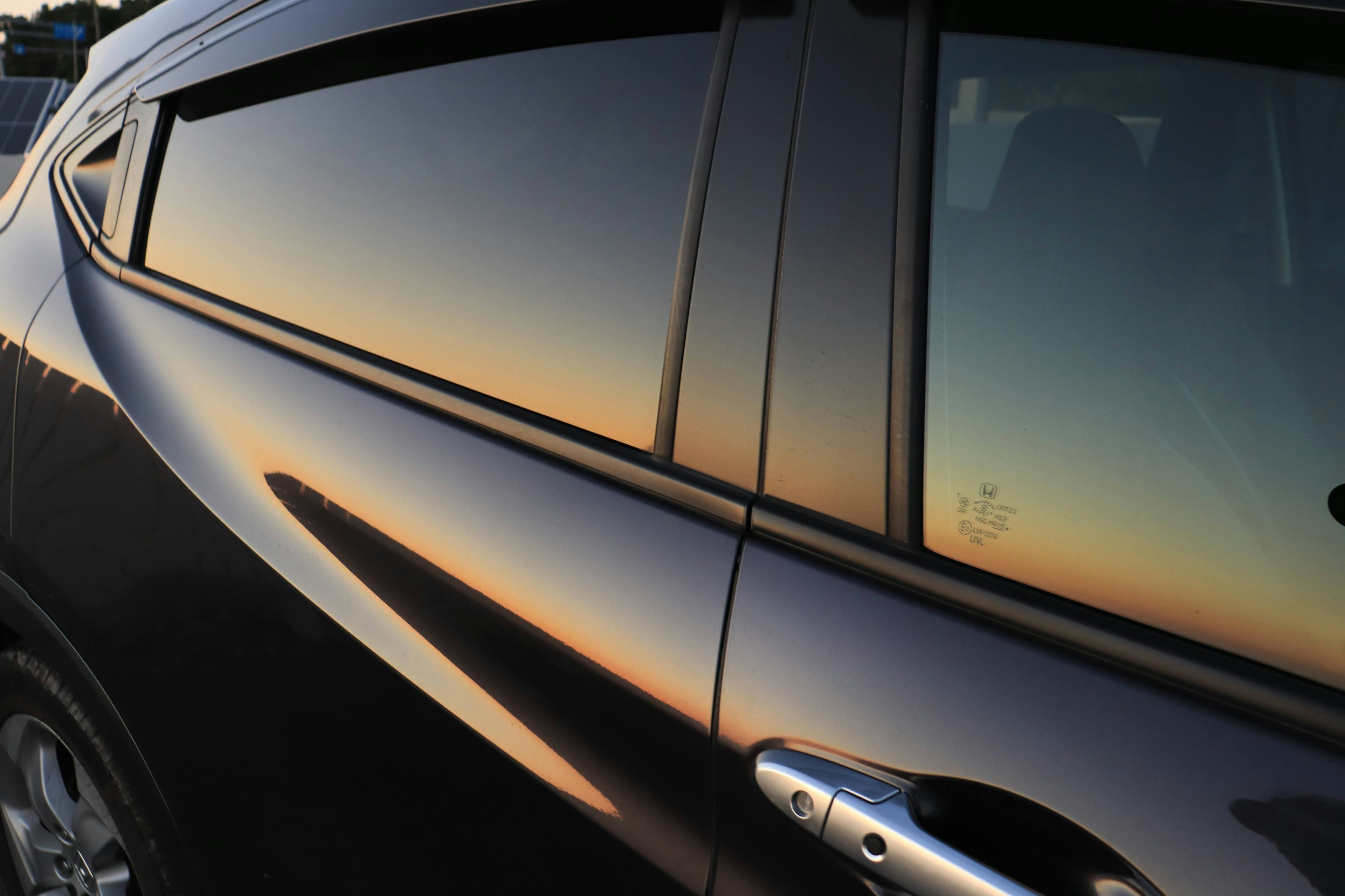 Riflessione del tramonto sul finestrino di un'auto nera