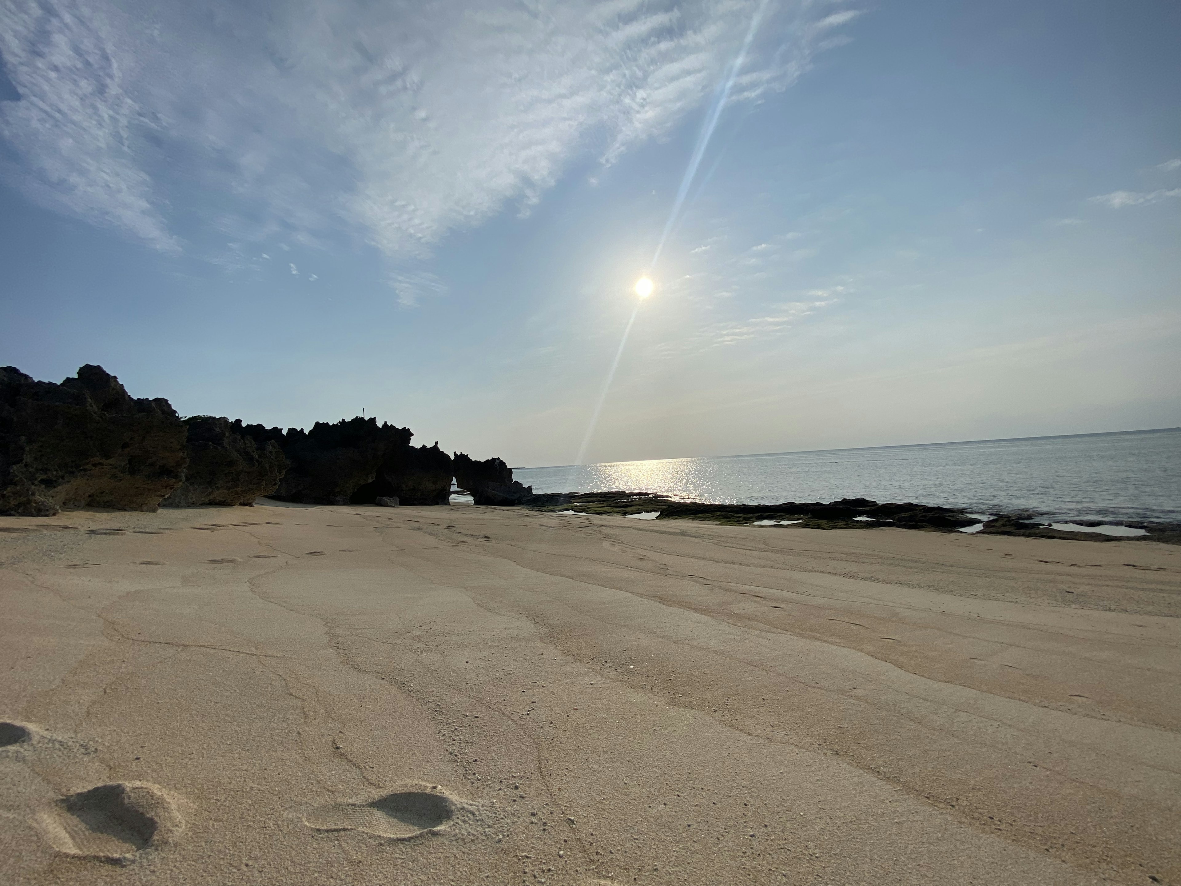 美しいビーチの風景、穏やかな海と岩の景観、青い空と太陽の光