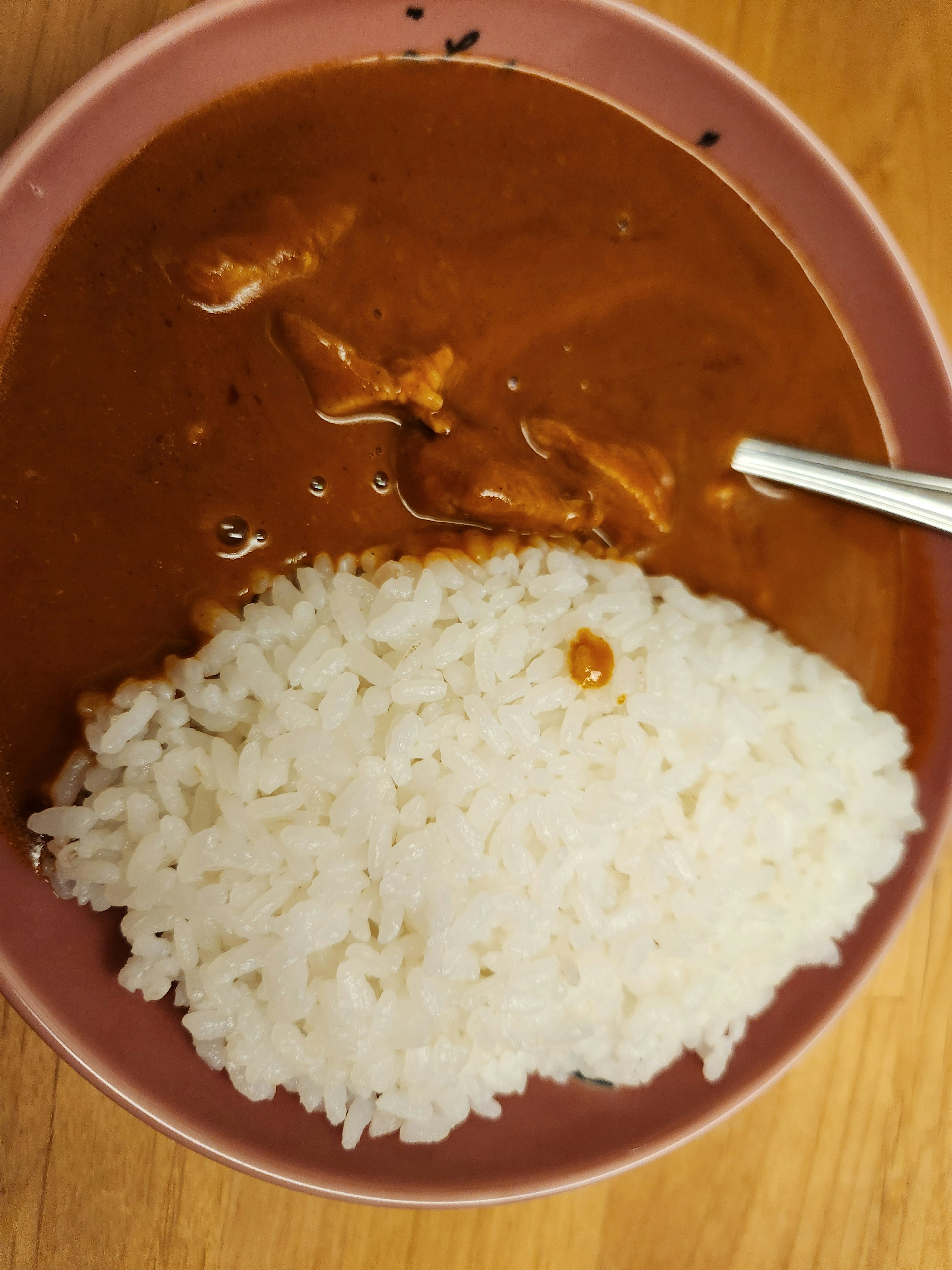 Teller mit brauner Currysauce und weißem Reis