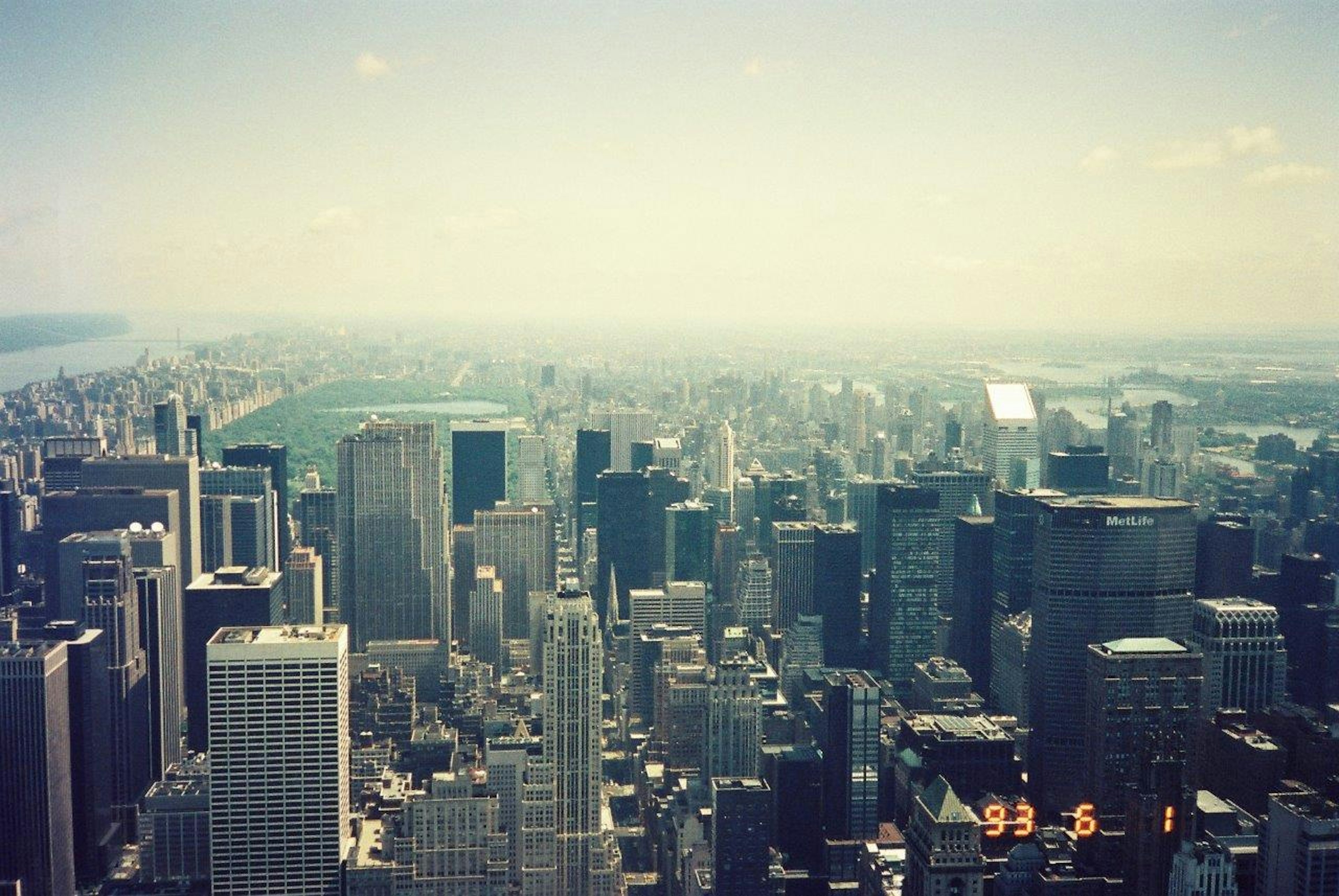 A panoramic view of New York City skyline with skyscrapers and distant water