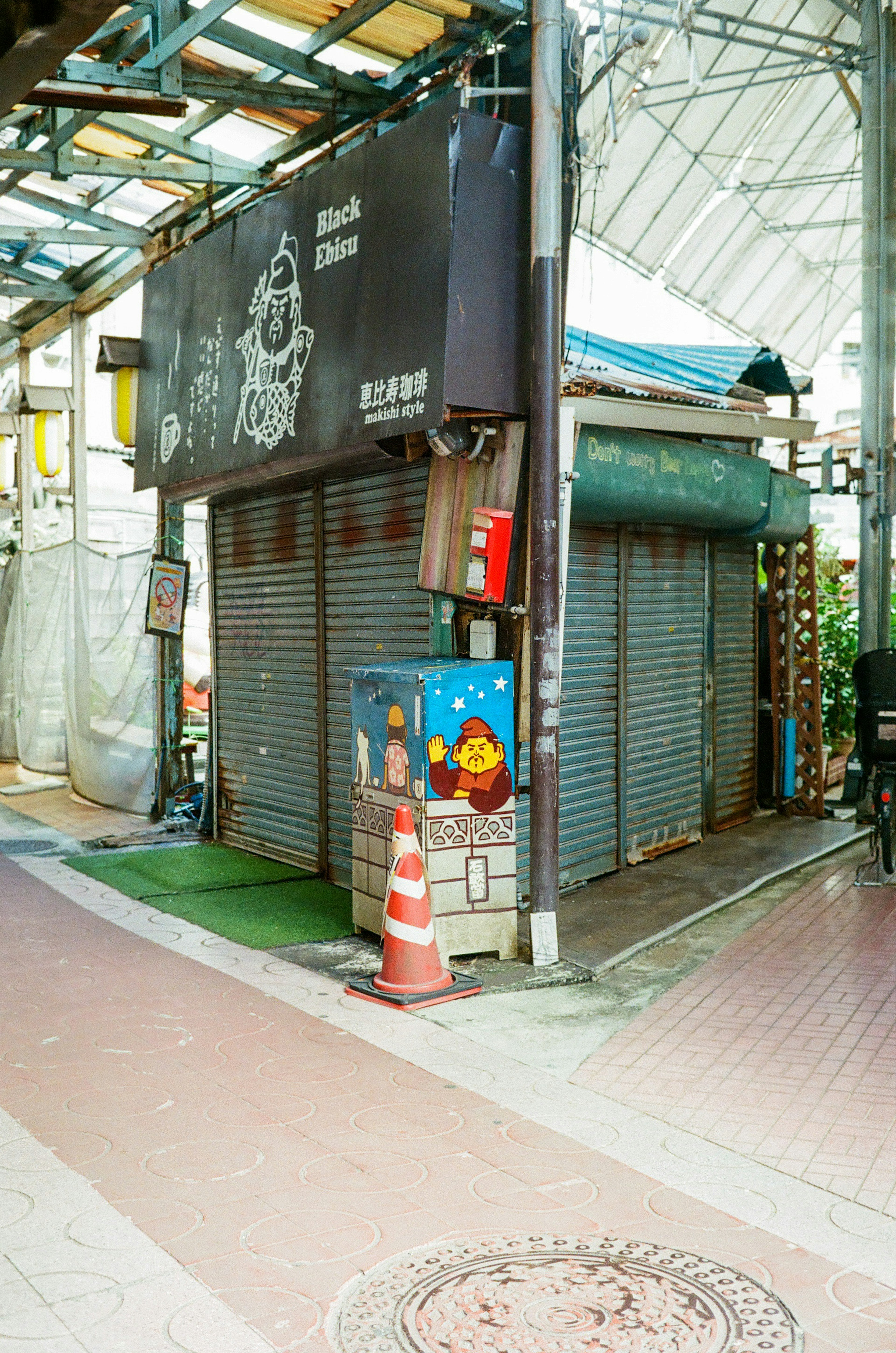 シャッターが閉じた店舗と周囲の通りの風景