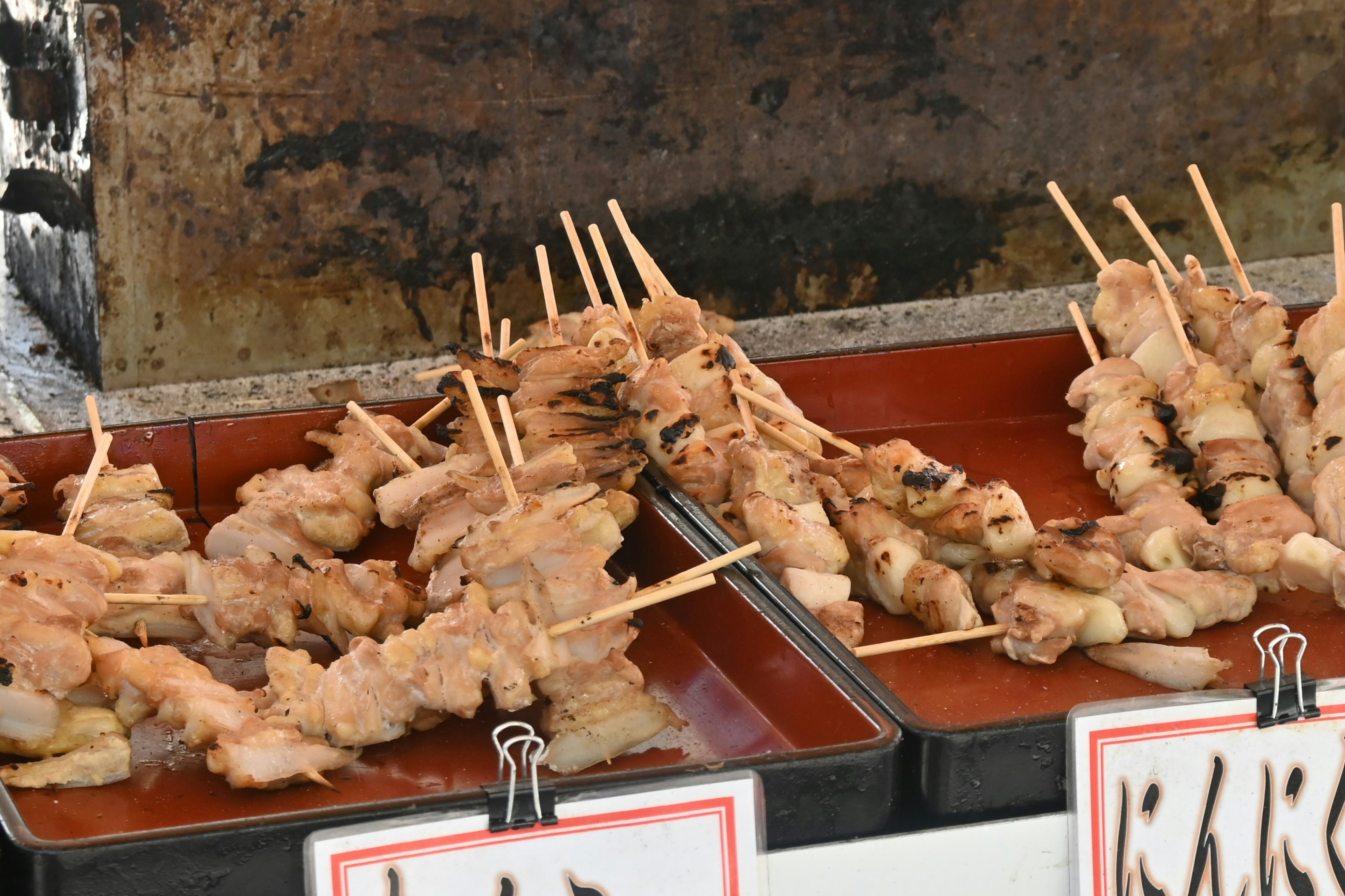 Skewers of grilled chicken displayed at a street food stall