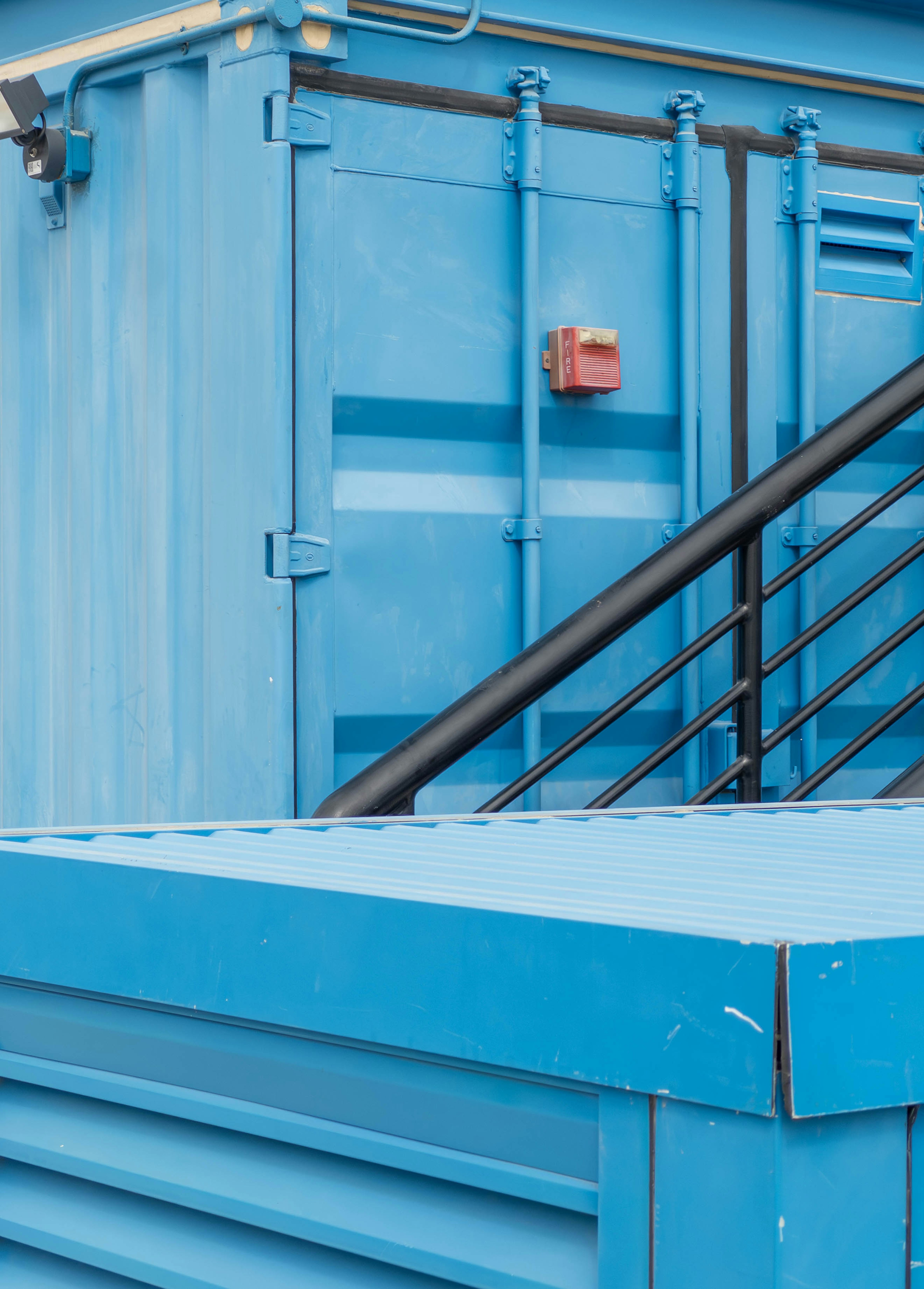 Bild zeigt einen blauen Container mit einer Treppe