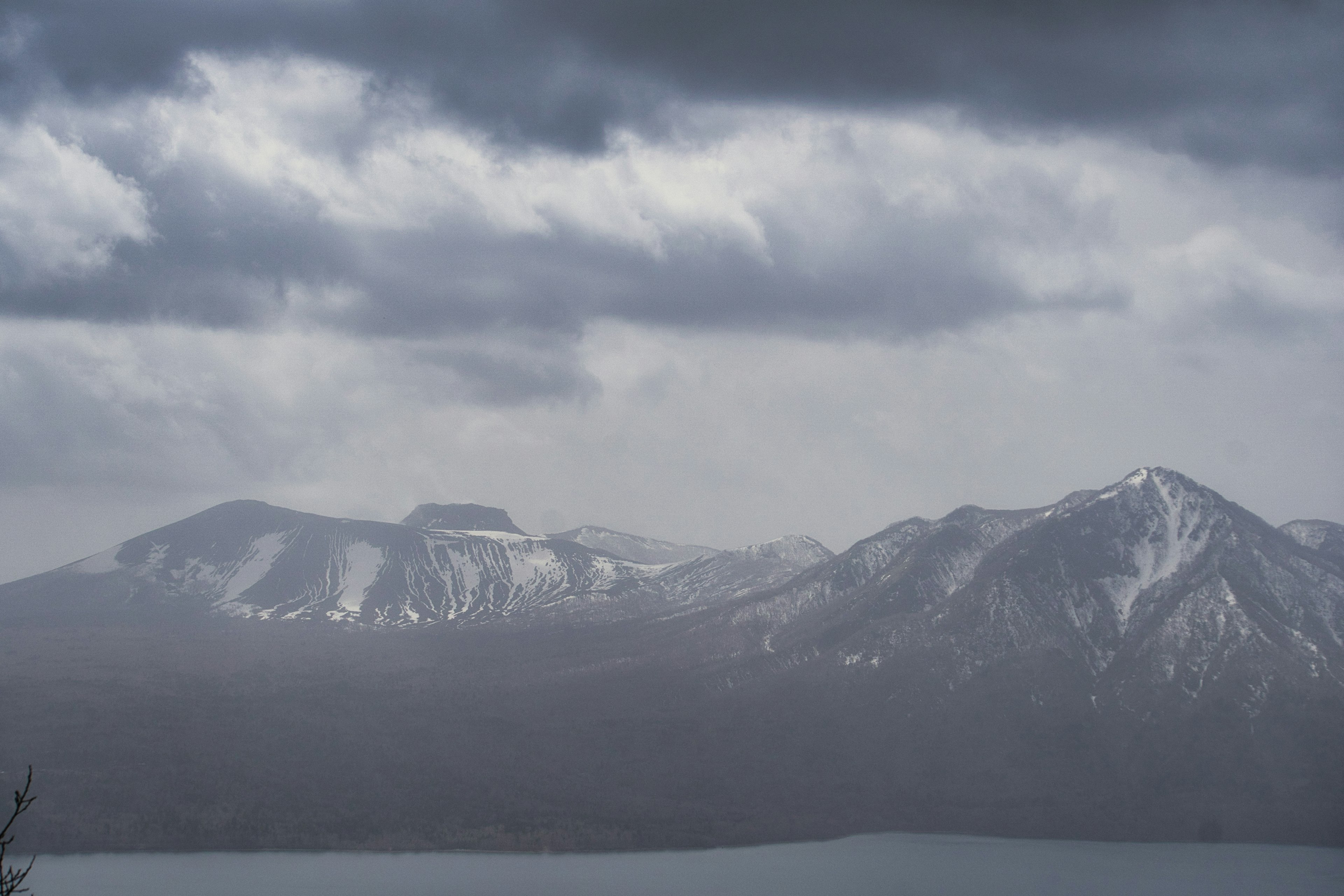 Montañas cubiertas de nieve bajo nubes oscuras