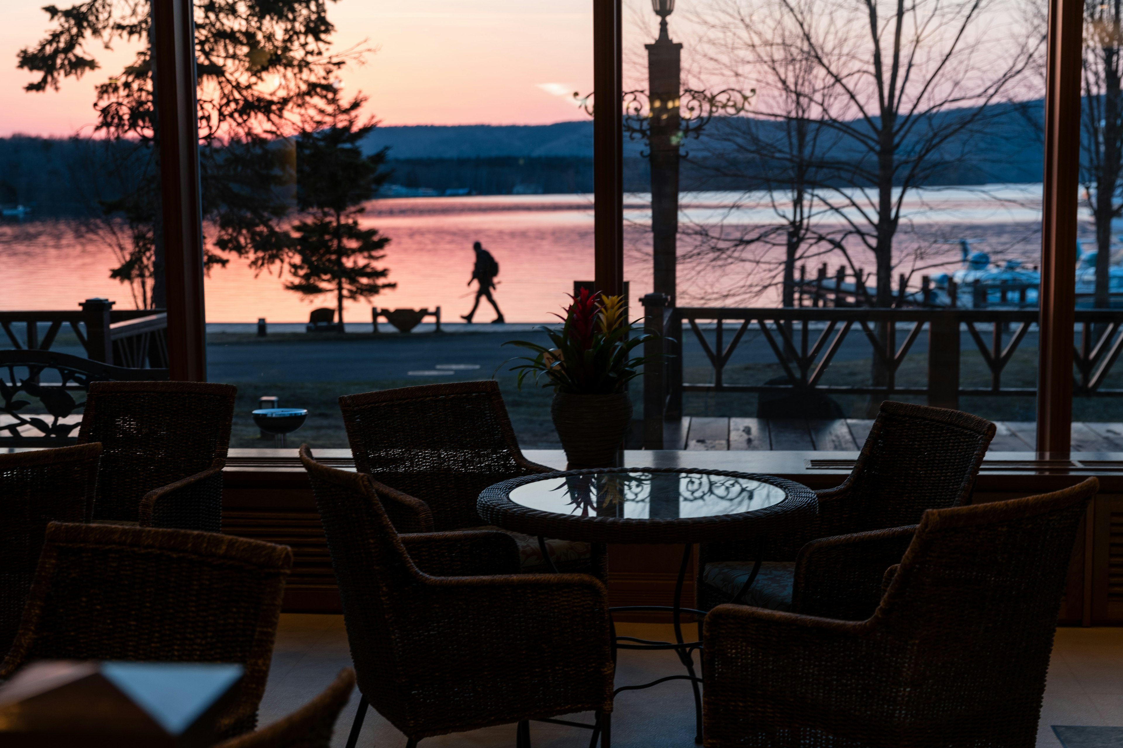 Vista interna di un caffè che si affaccia su un lago al tramonto