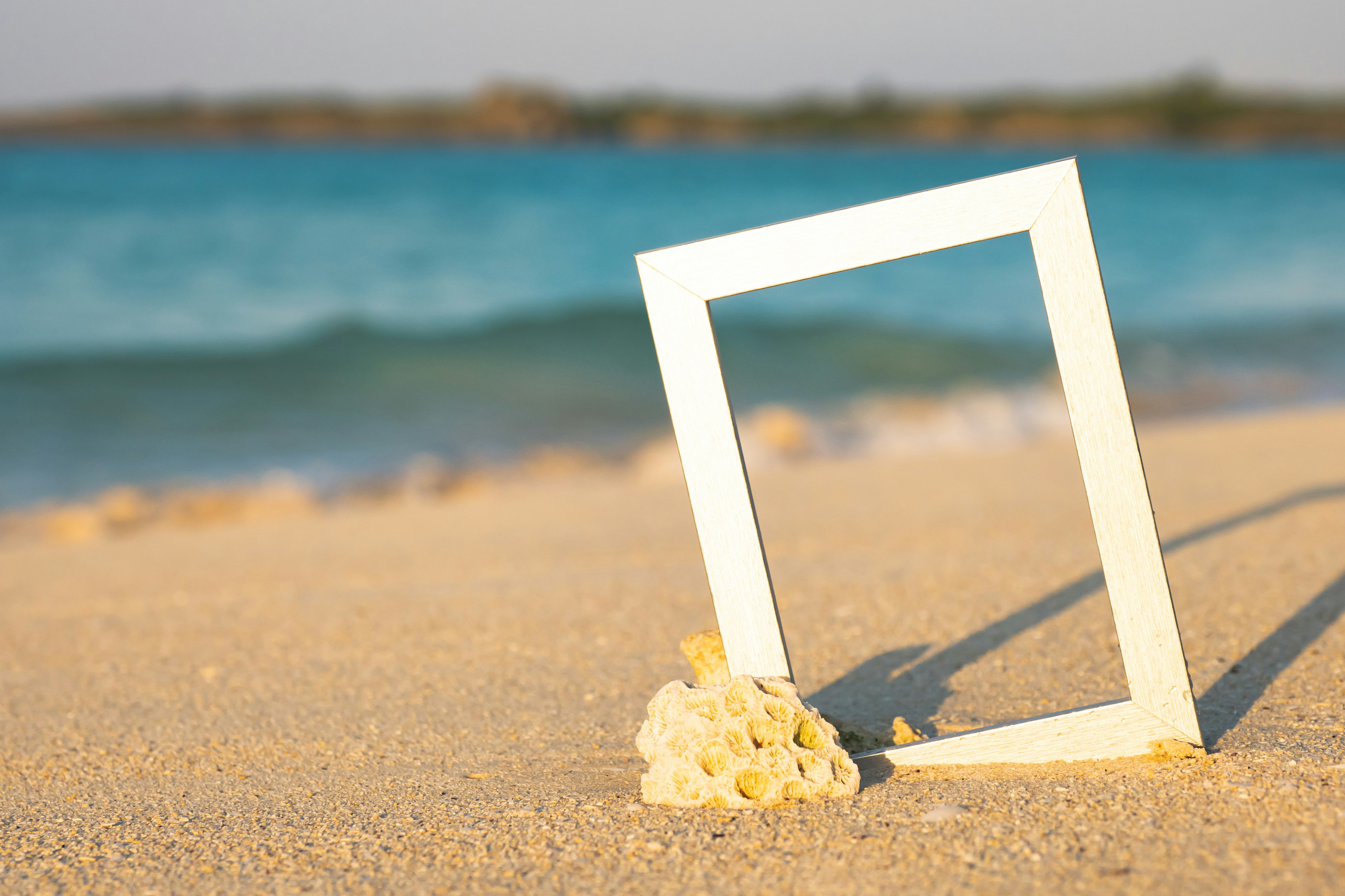 Cornice bianca e bouquet sulla spiaggia di sabbia con sfondo oceano