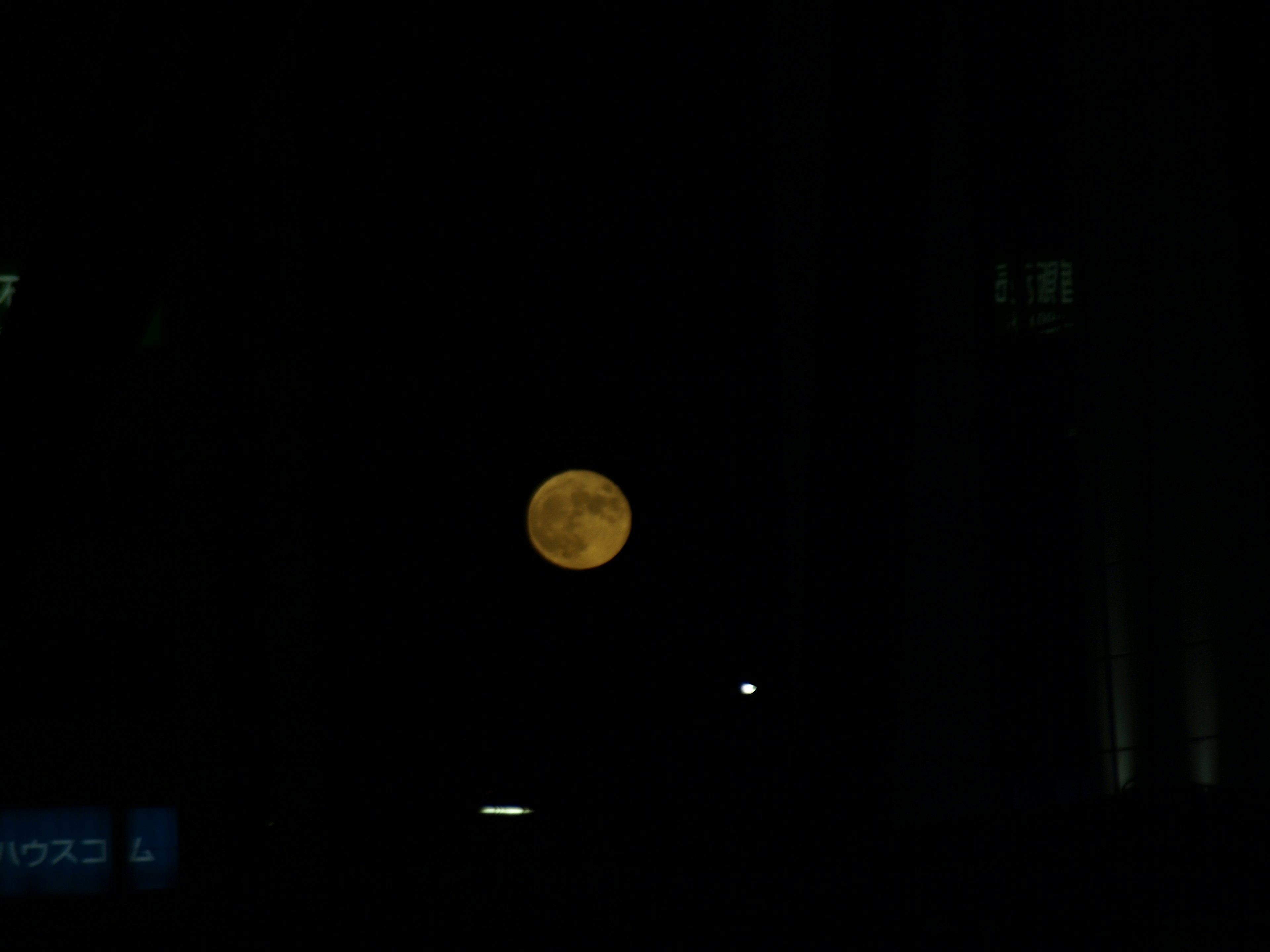 Orange moon in the night sky with a dark background