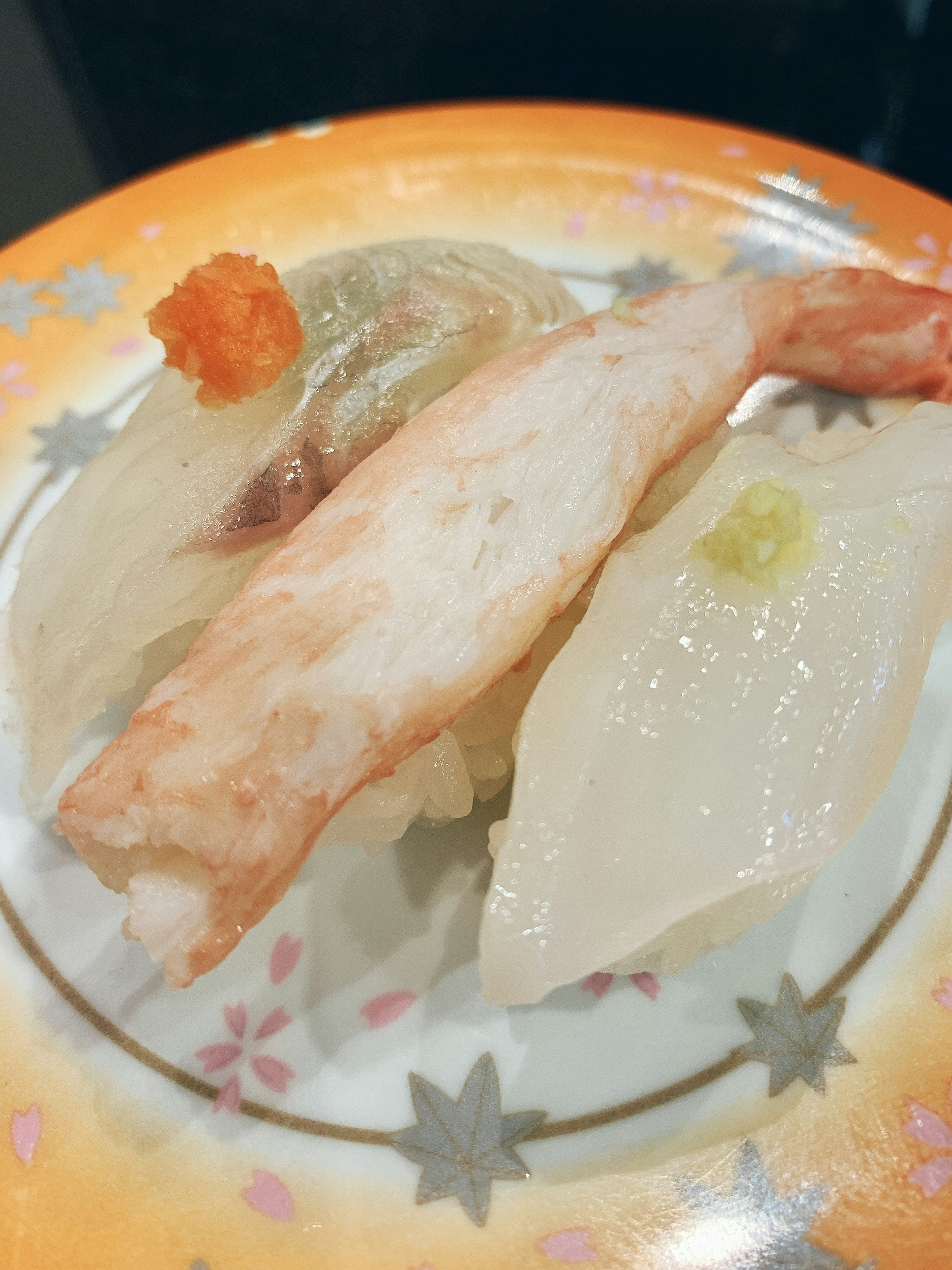 Assorted sushi featuring shrimp, crab, white fish on a colorful plate