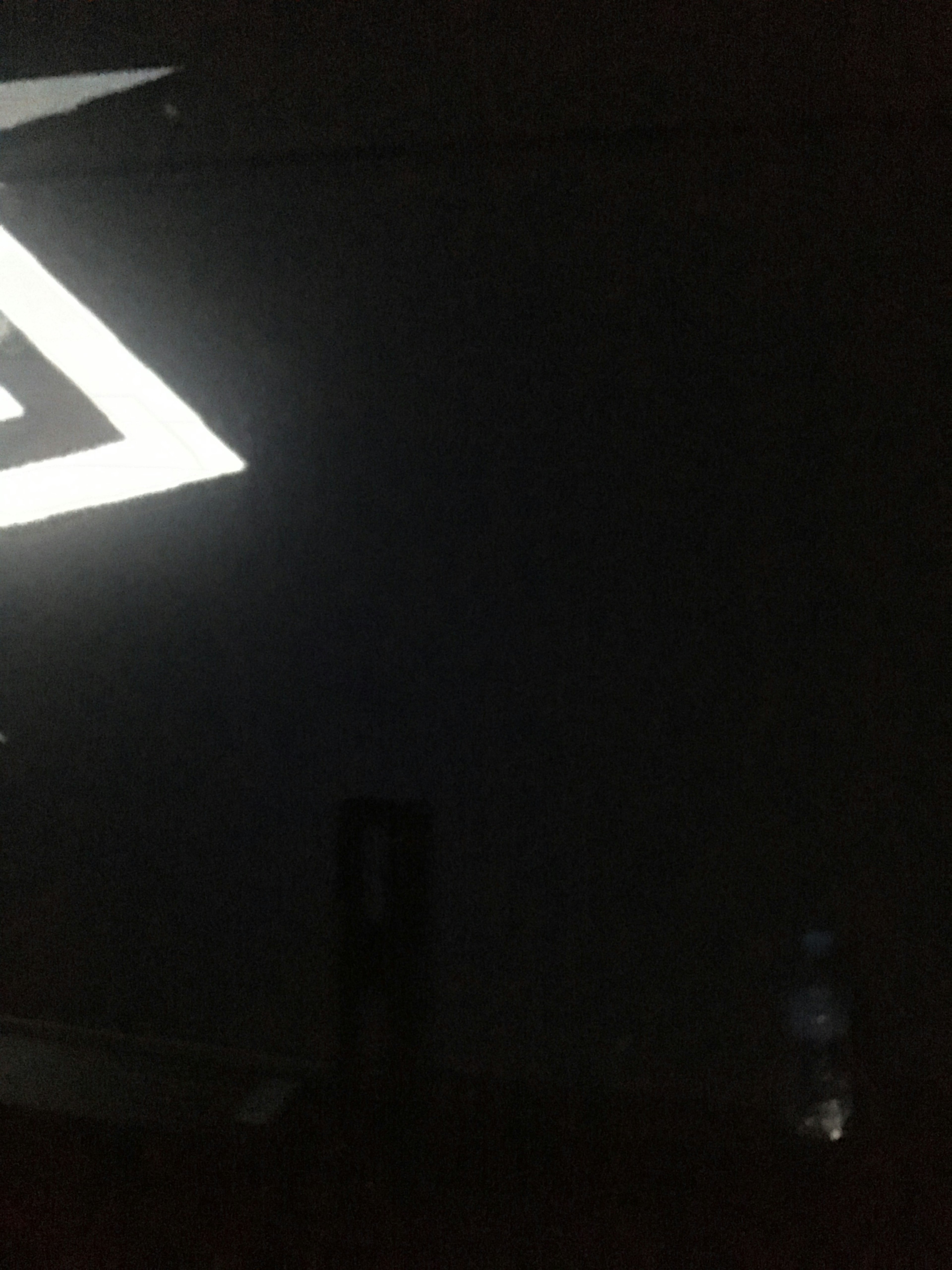 Imagen que muestra un reflejo de luz triangular blanca sobre un fondo oscuro