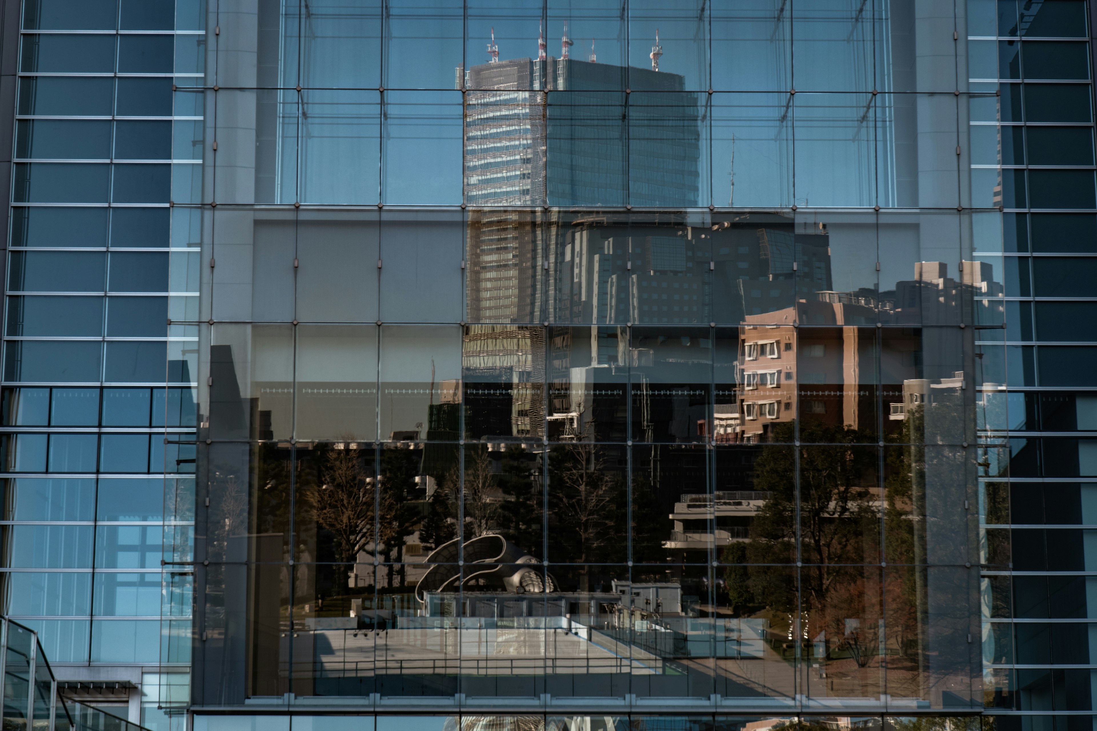 Riflessione del paesaggio urbano e del cielo blu nelle finestre di un grattacielo