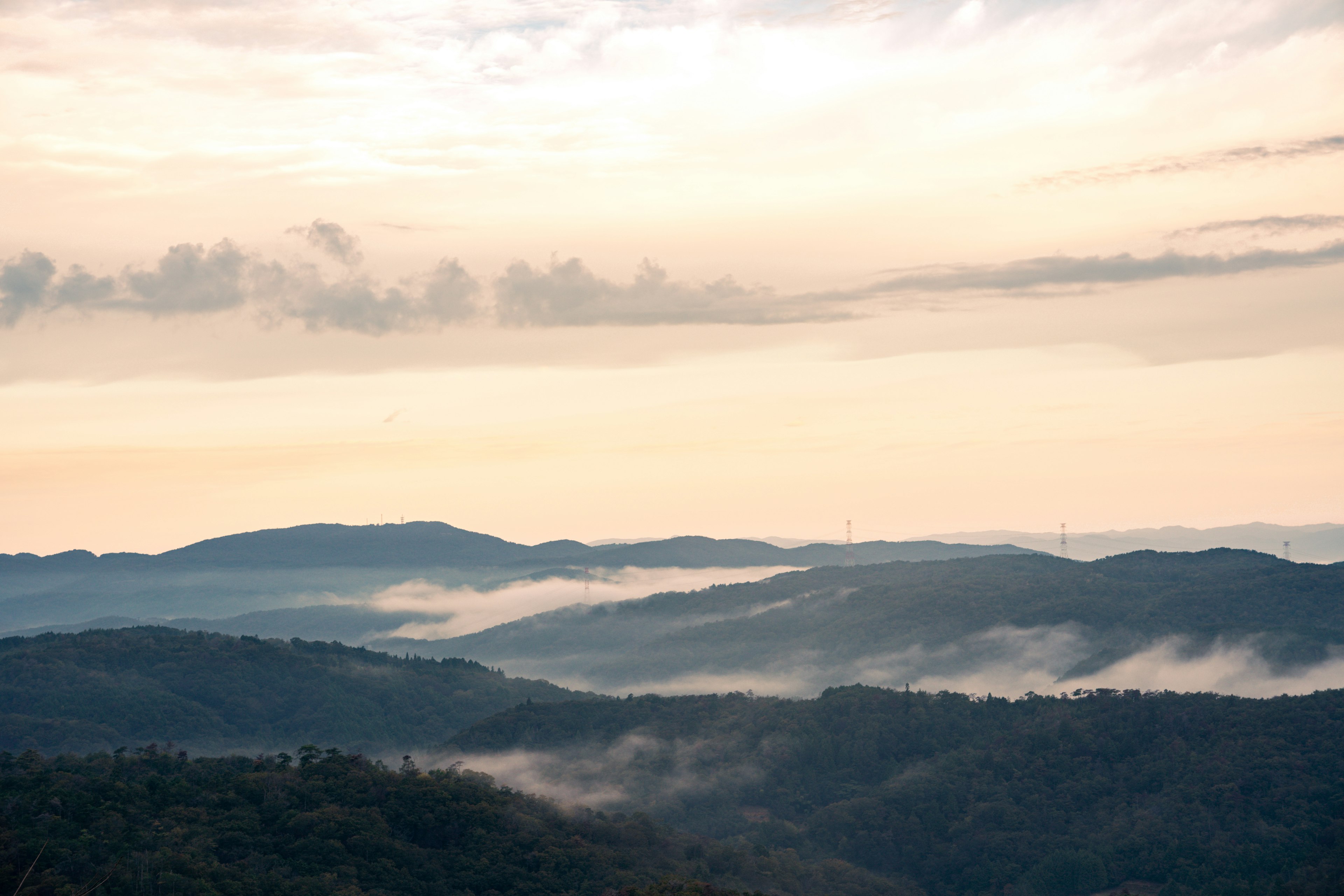 Pemandangan pegunungan dengan kabut dan awan saat senja