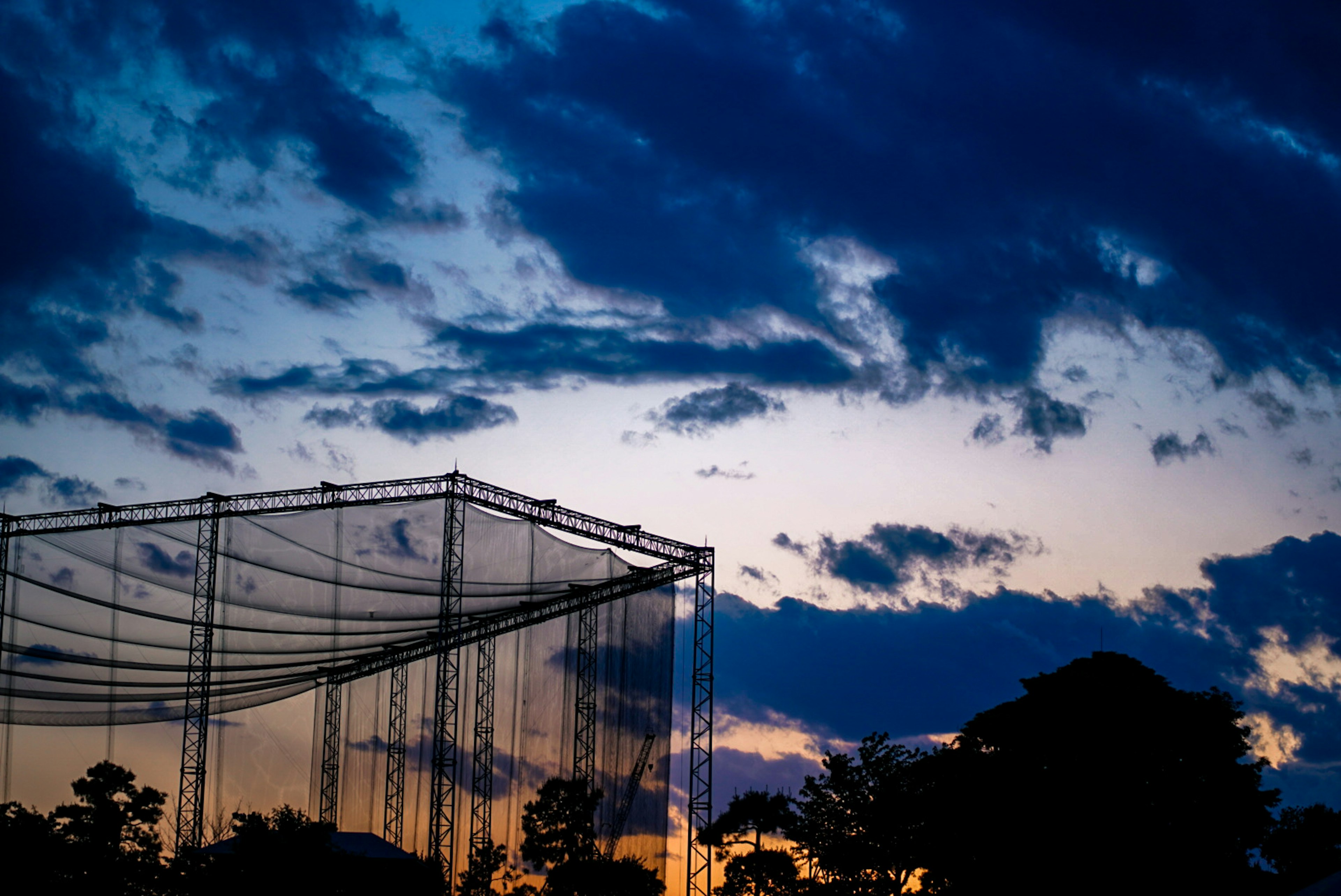 Siluet jaring driving range di bawah langit senja