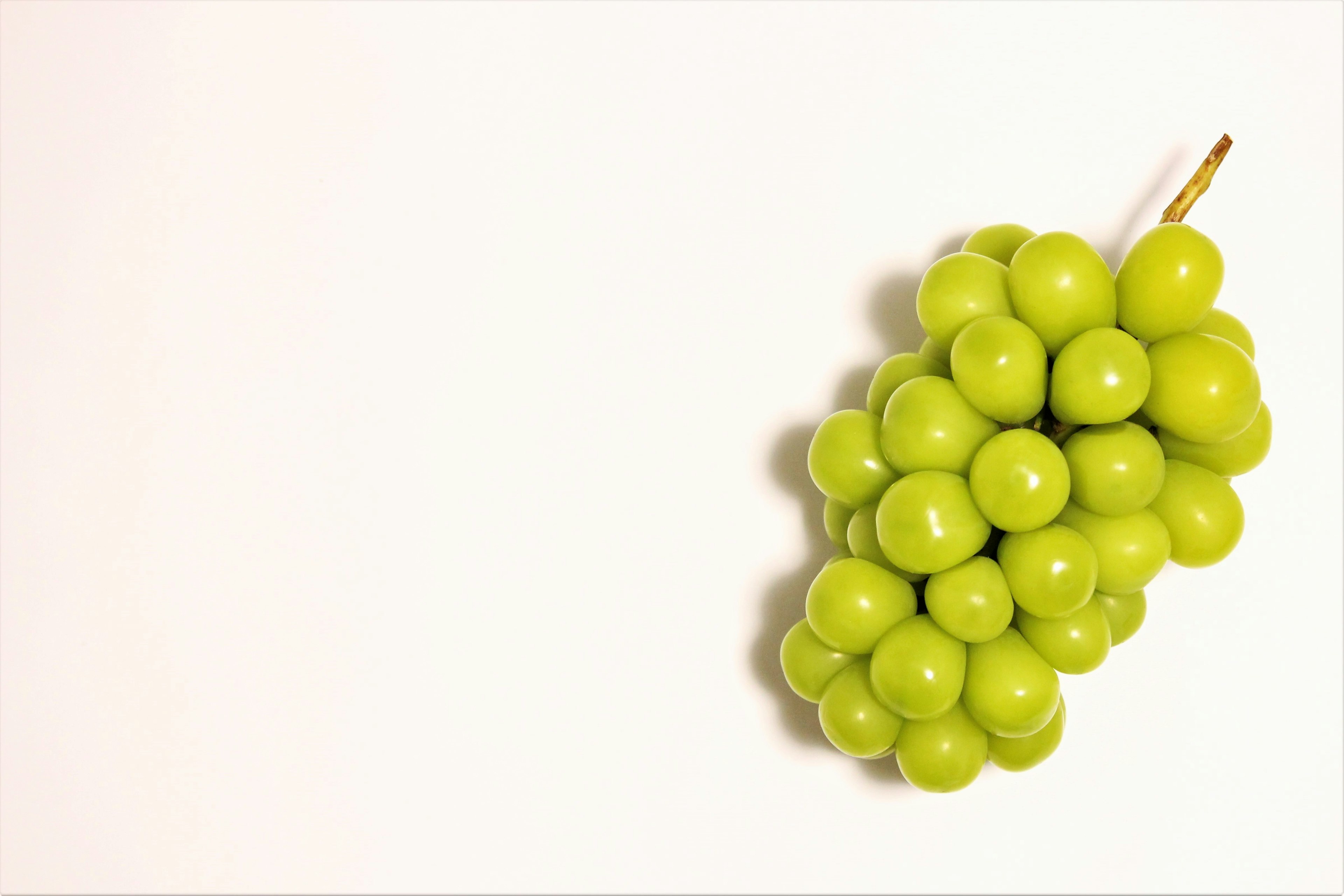 A cluster of green grapes on a white background