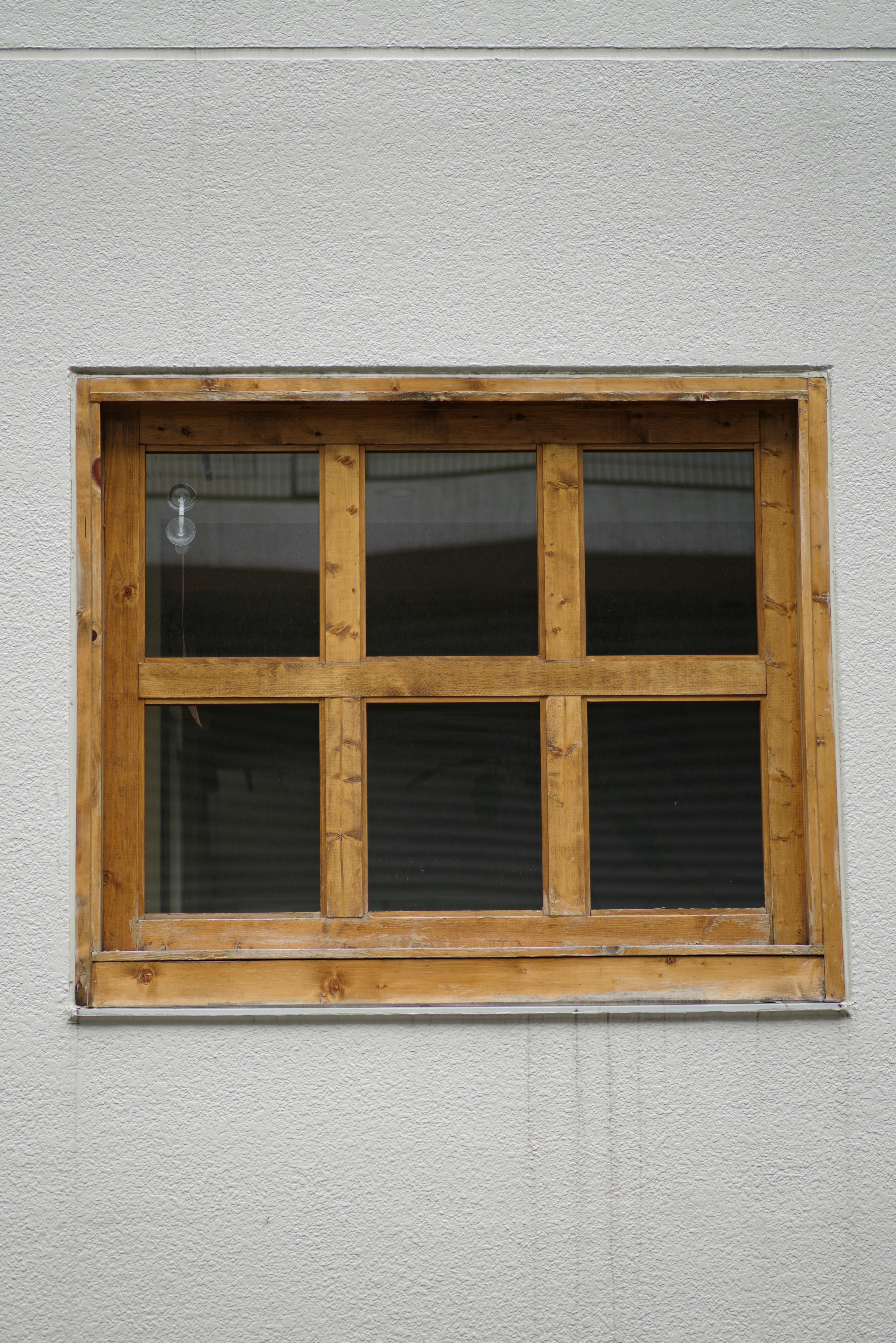 Simple window with a wooden frame featuring a grid design