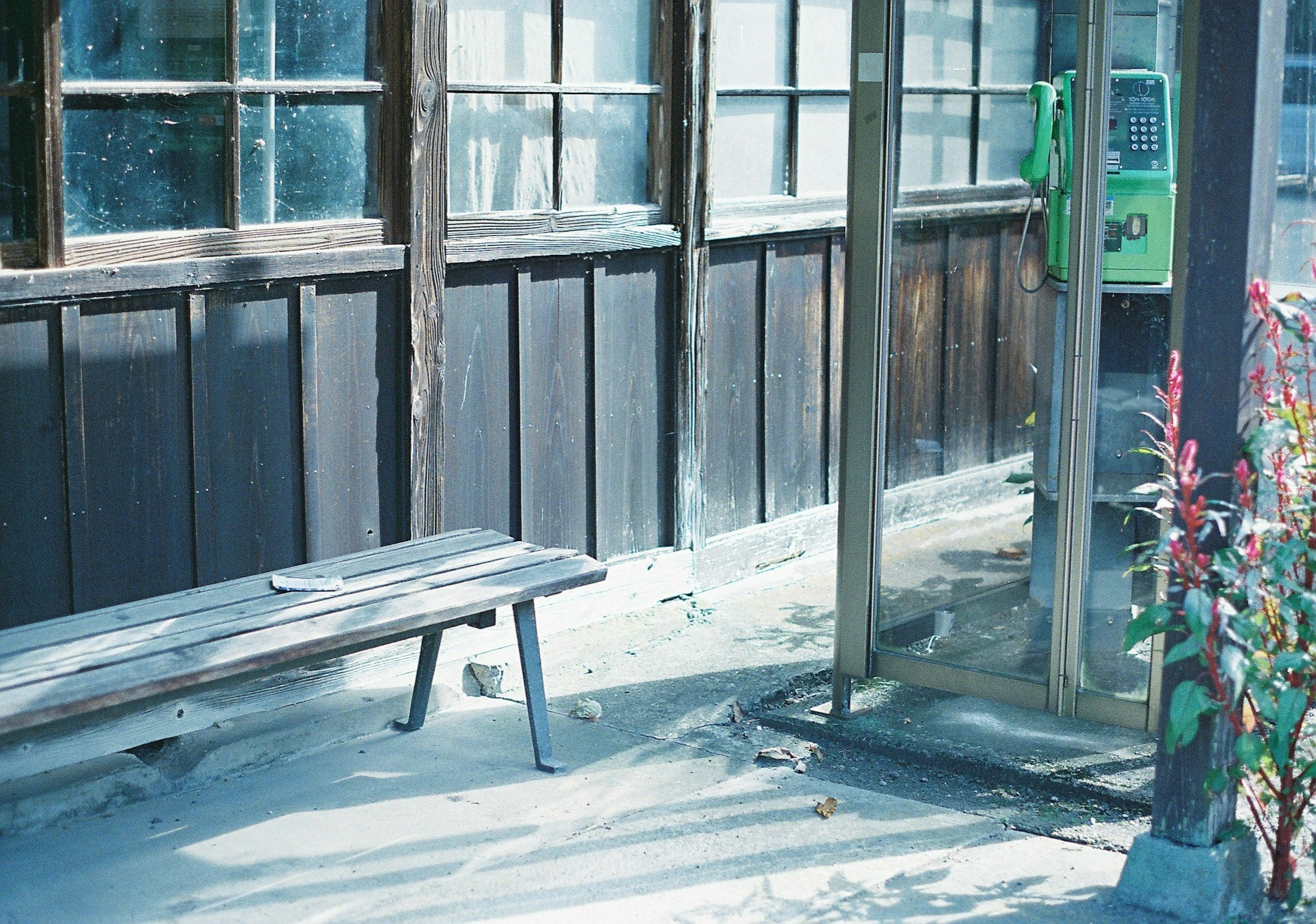 Quiet scene featuring an old phone booth and a bench