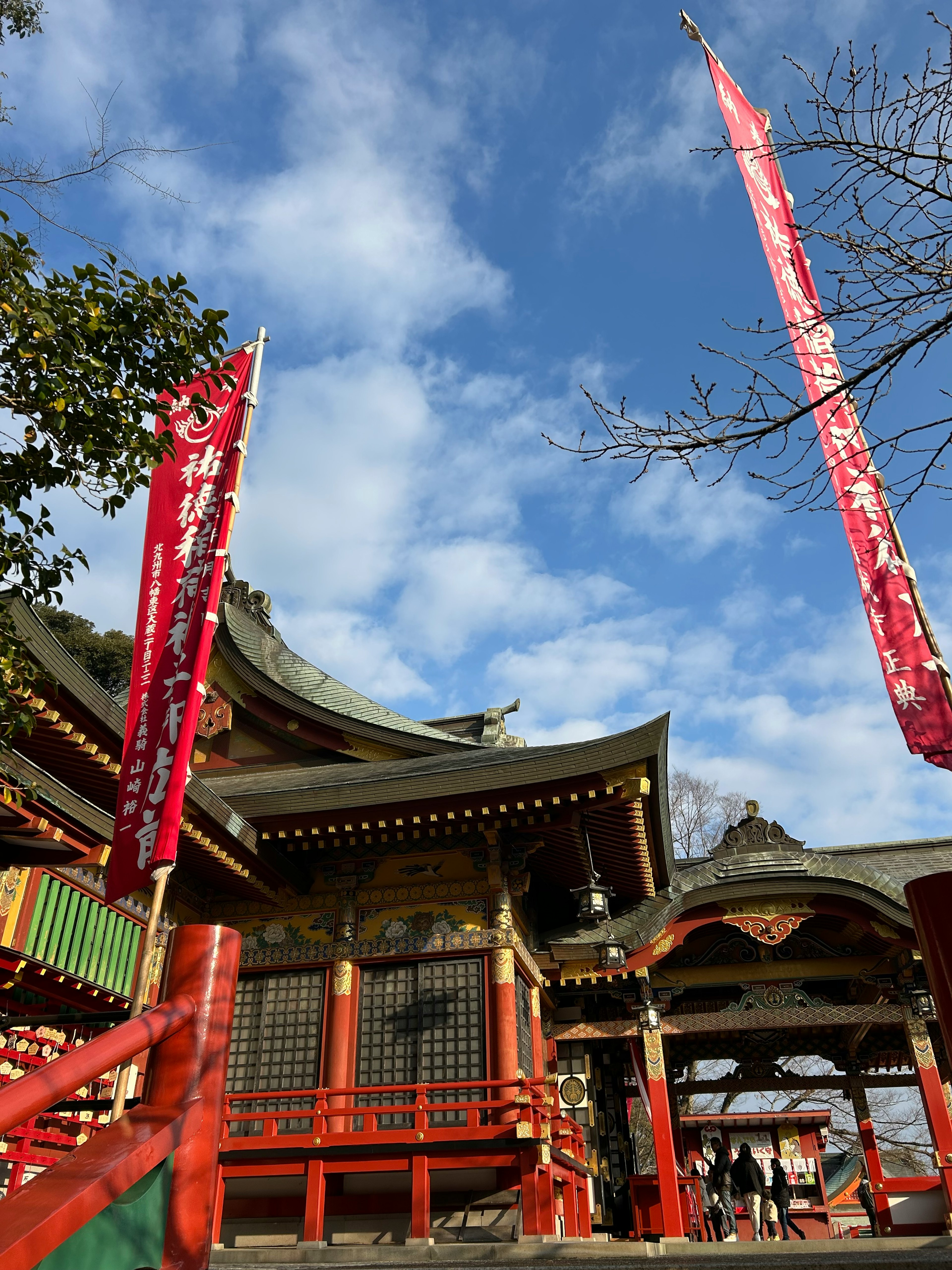 赤い旗と青空の下の伝統的な日本の神社の建物