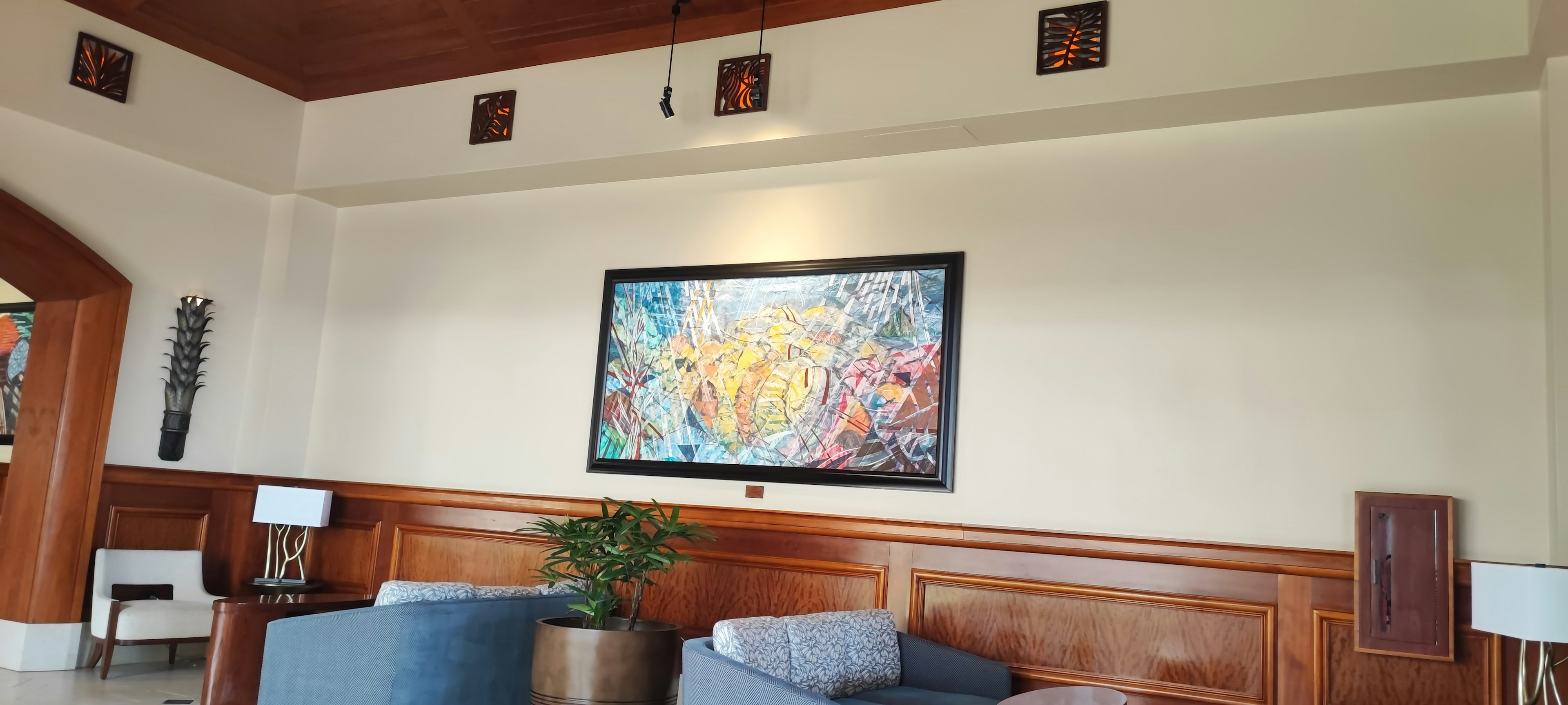 Sala moderna con una obra de arte colorida en la pared y muebles acogedores