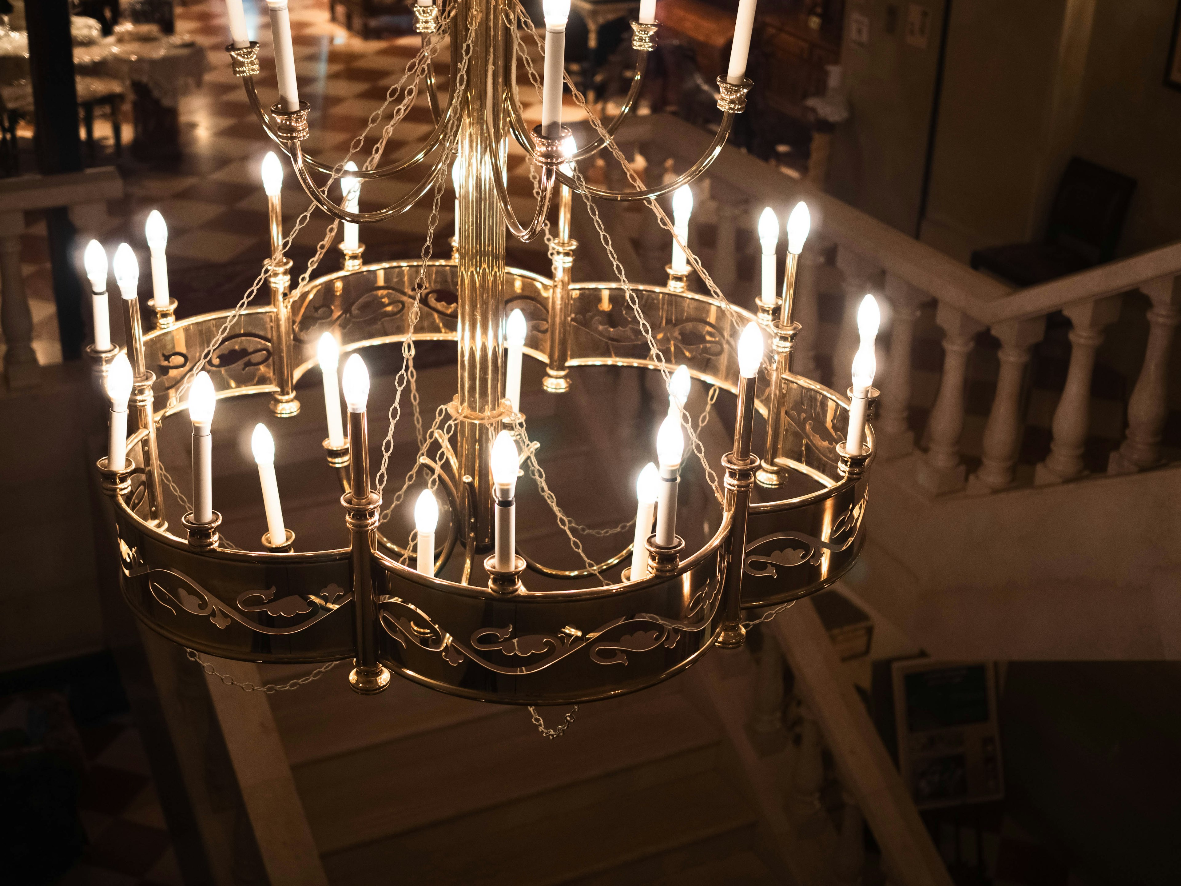 A luxurious chandelier illuminating a staircase from above