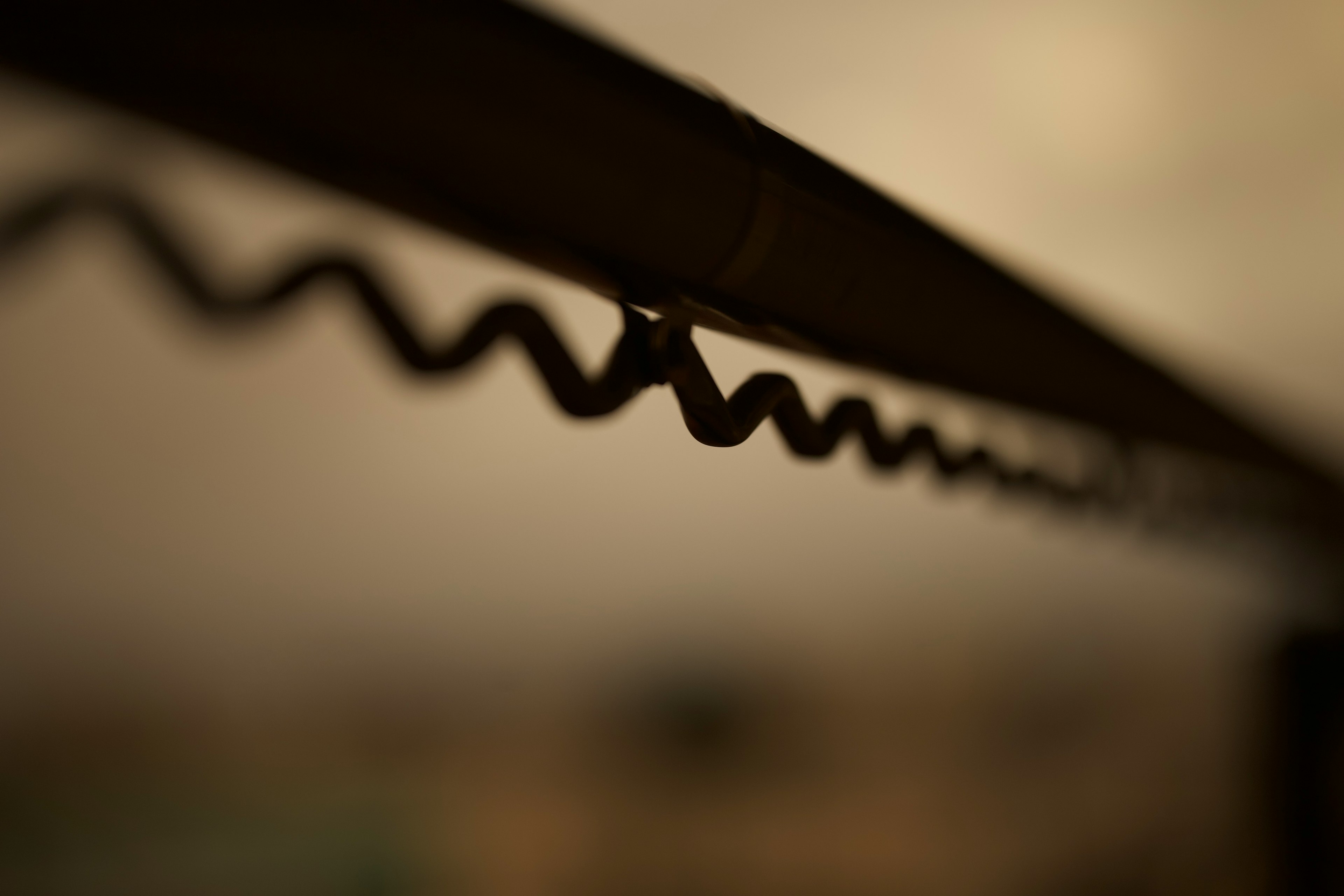 Close-up photo of a black metal wire with a wavy pattern