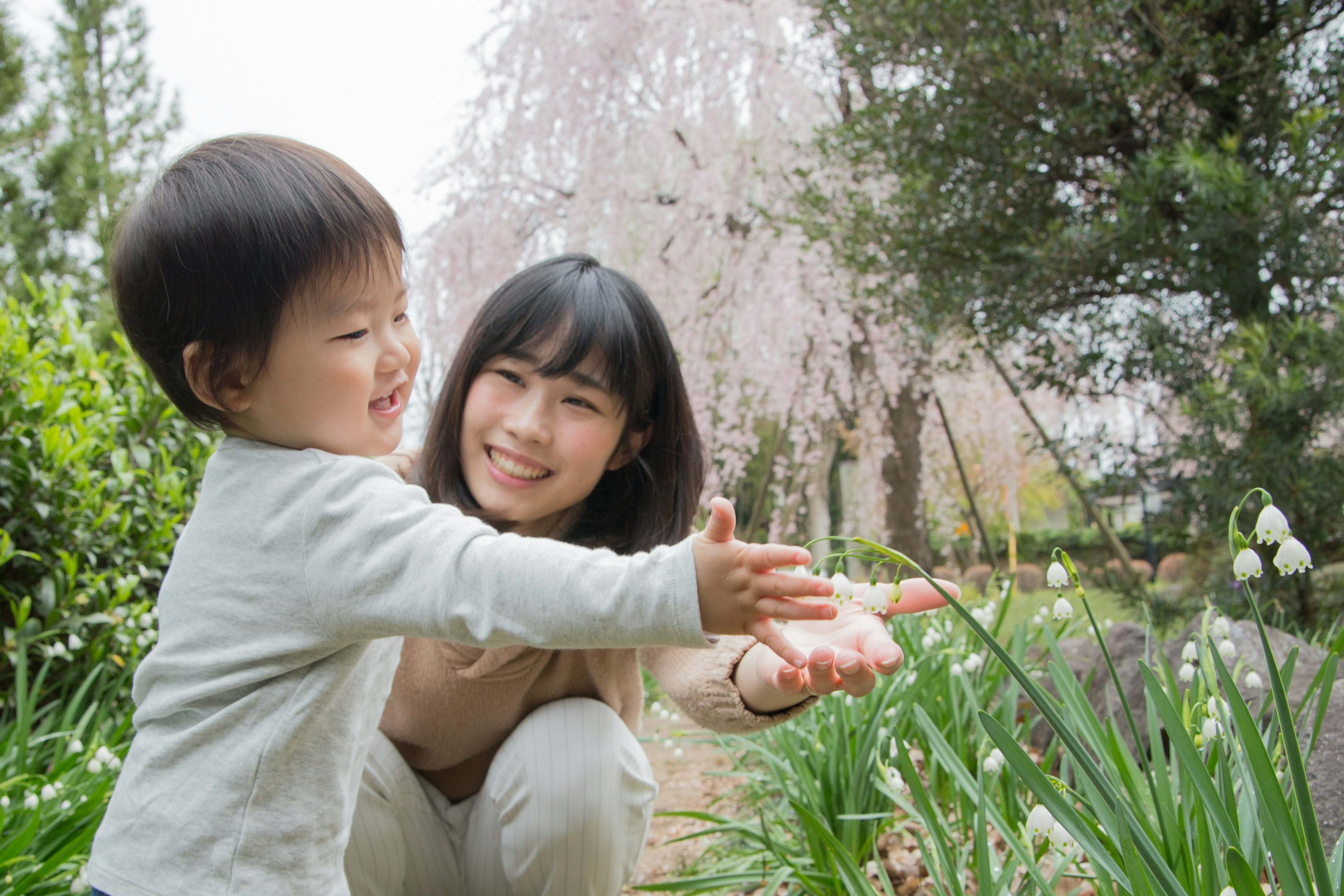 Una madre y su hijo jugando alegremente en un jardín de primavera